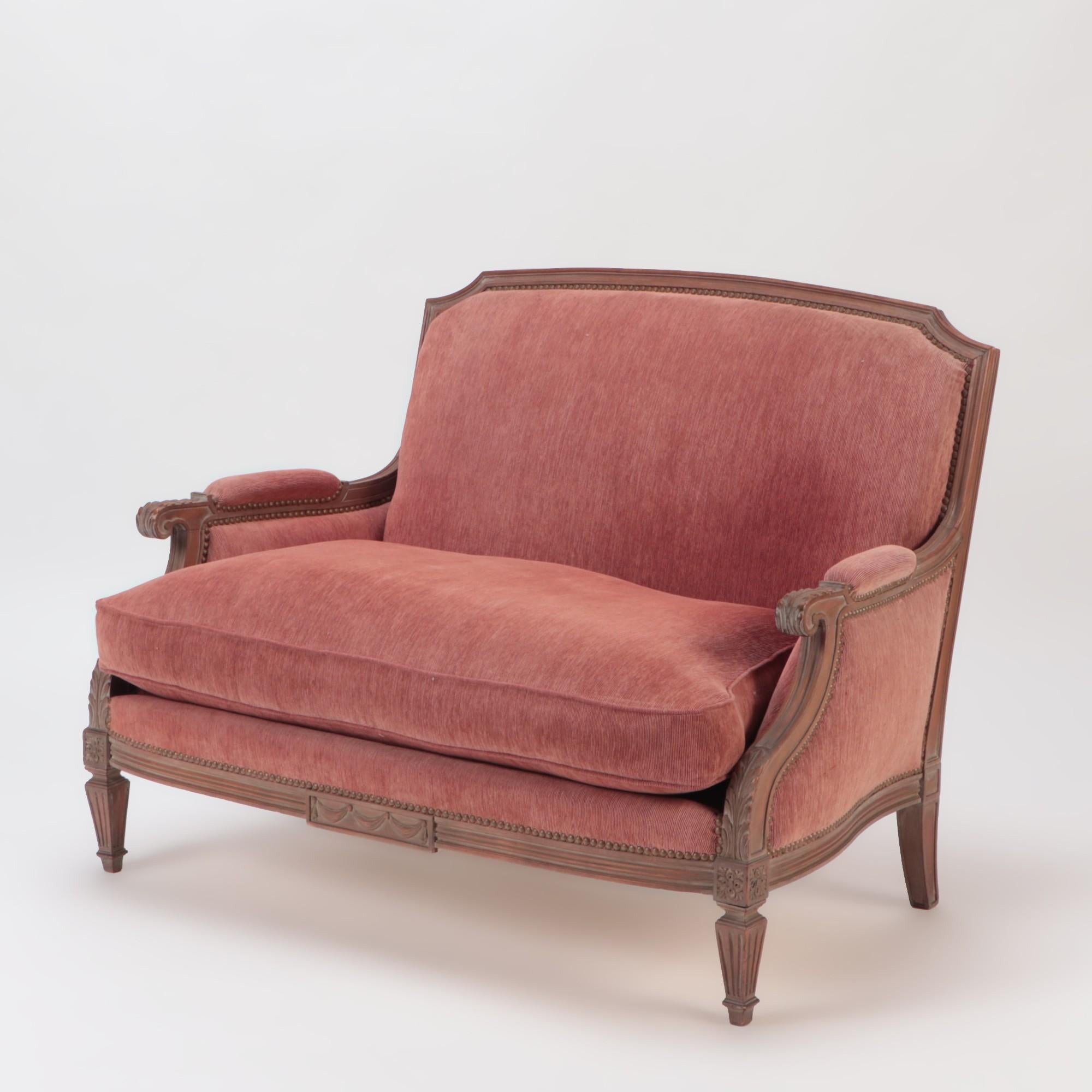 A pair of cerused mahogany Louis XVI style upholstered Marquises (wide bergère chairs), France, circa 1940.
The armchairs have a straight back, topped with a carved upper rail. Raised on four fluted tapered legs topped with carved rosettes.