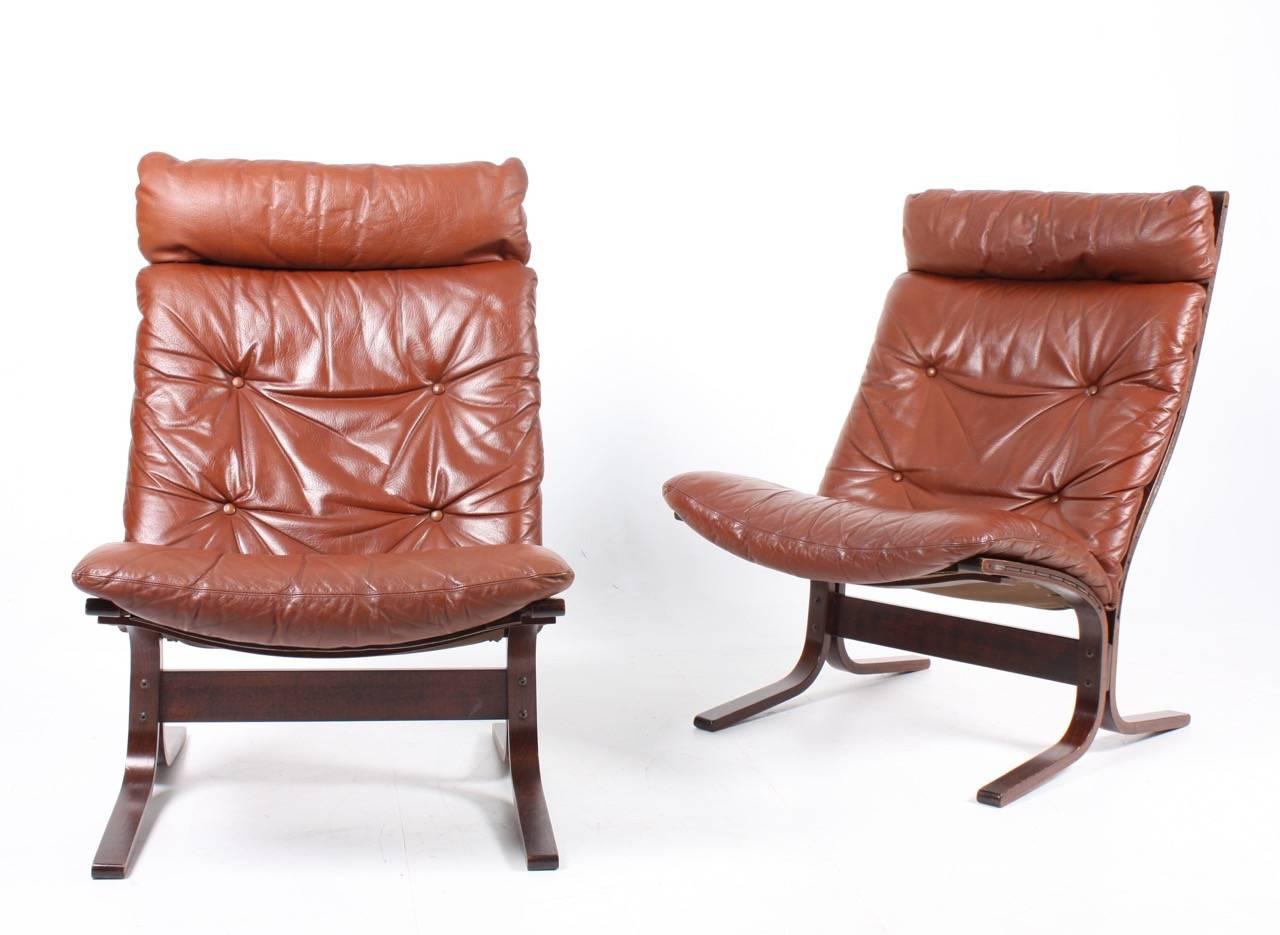 A pair of great looking and very comfortable lounge chairs in plywood and patinated leather designed by Ingmar Relling in 1965. Made in Norway. Great original condition.