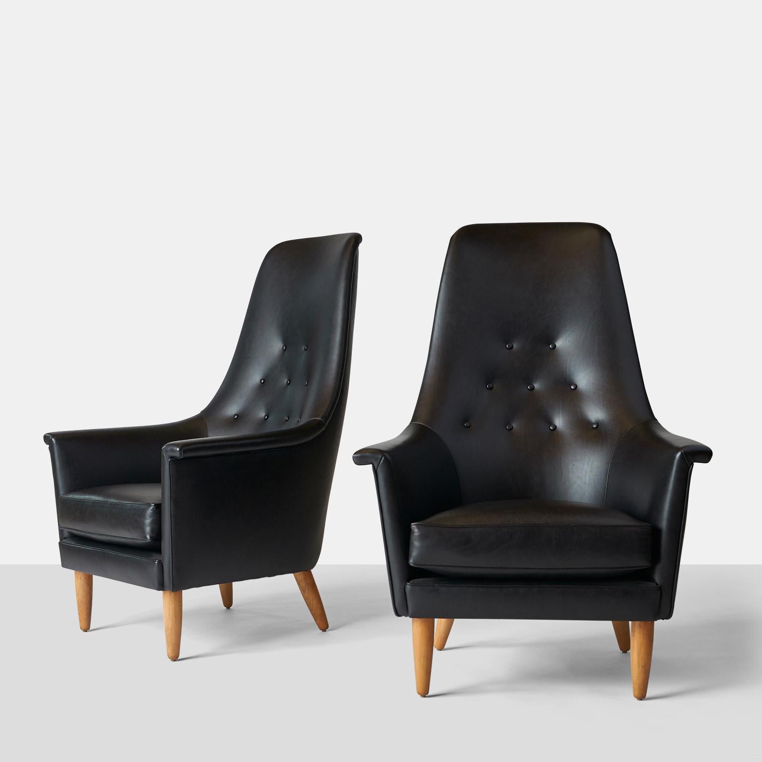 A pair of comfortable high back chairs for Illums Bolighus department store. Previously re-foamed, refinished, and reupholstered in a smooth black leather. Tufted back, with cushioned seat. Design attributed to Ib Kofod-Larsen.