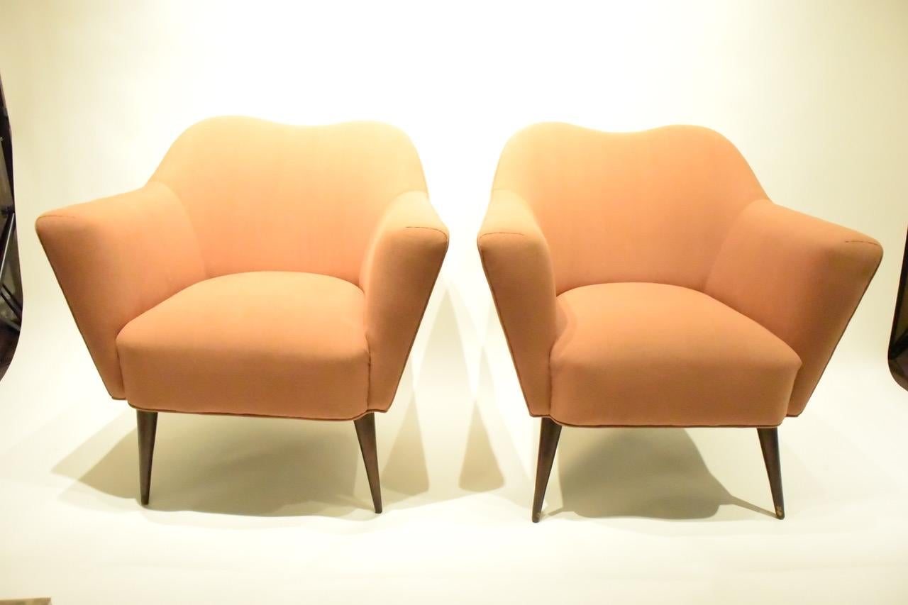 A pair of lounge chairs. These stylish chairs with beautiful lines have been recently reupholstered in a neutral flesh tone linen cotton blend fabric. 
1950s.