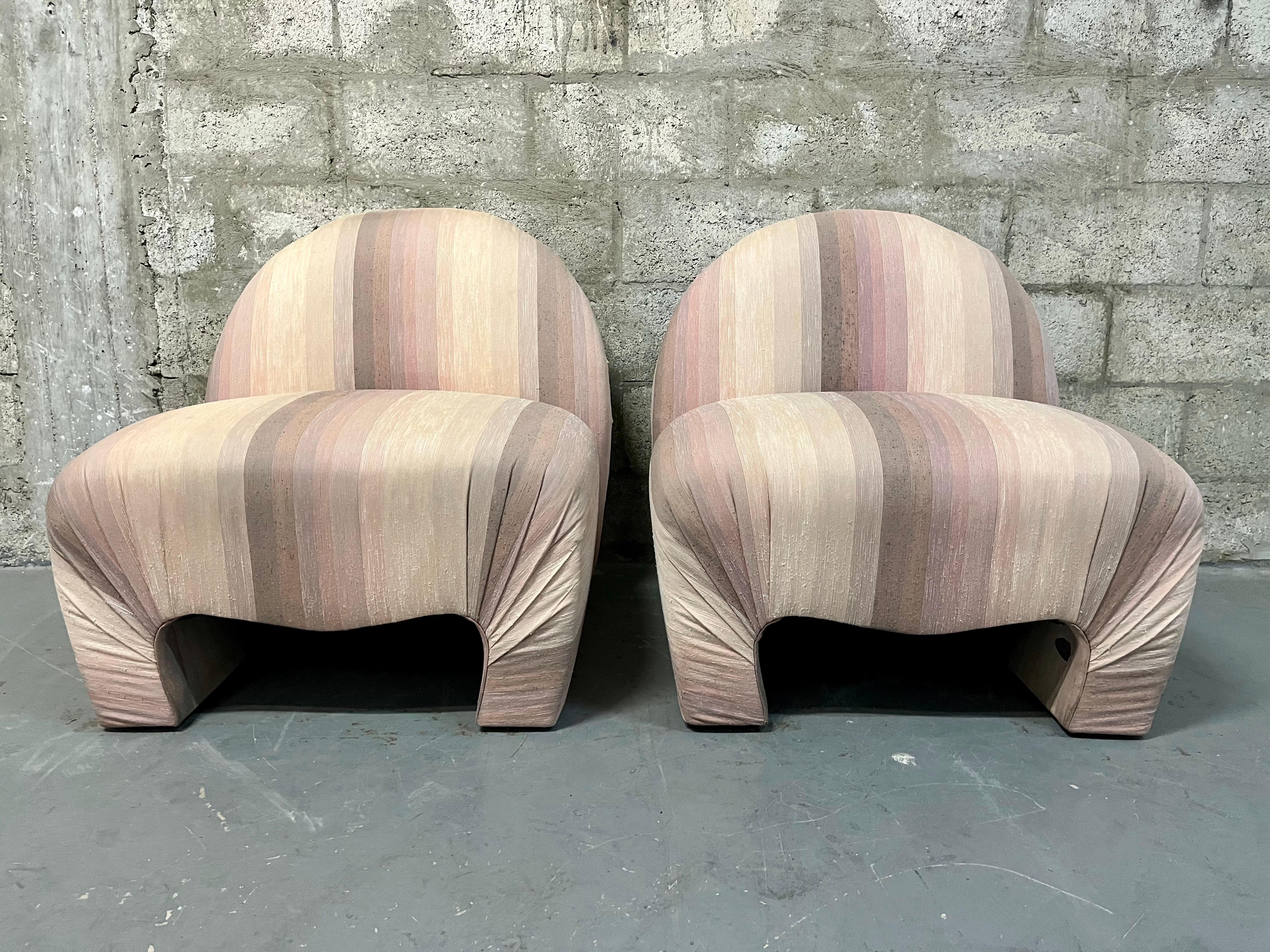 A Pair of Upholstered Lounge Chairs in the Vladimir Kagan for Weiman Furniture Style. Circa 1980s
Feature a post modern low-level living profile with soft curved lines, rounded edge, and the original striped upholstery in cream, lilac, peach, tan,