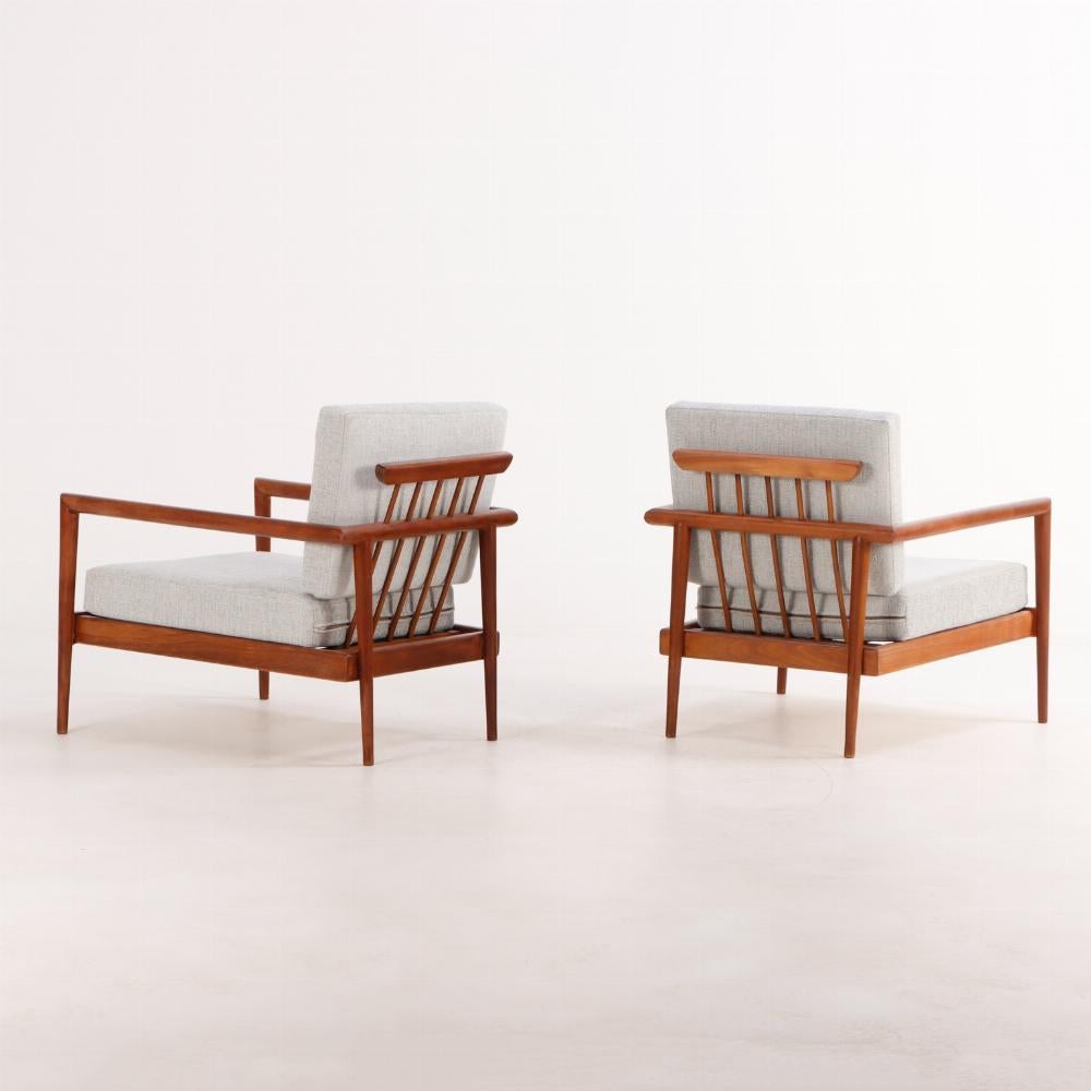 A pair of lounge chairs with Windsor style backs designed by Edmund Spence (American, 1911-1986). These beautiful chairs have a modern elegance thanks to sleek mahogany frames with spindle backs and are ready to enjoy having been professionally