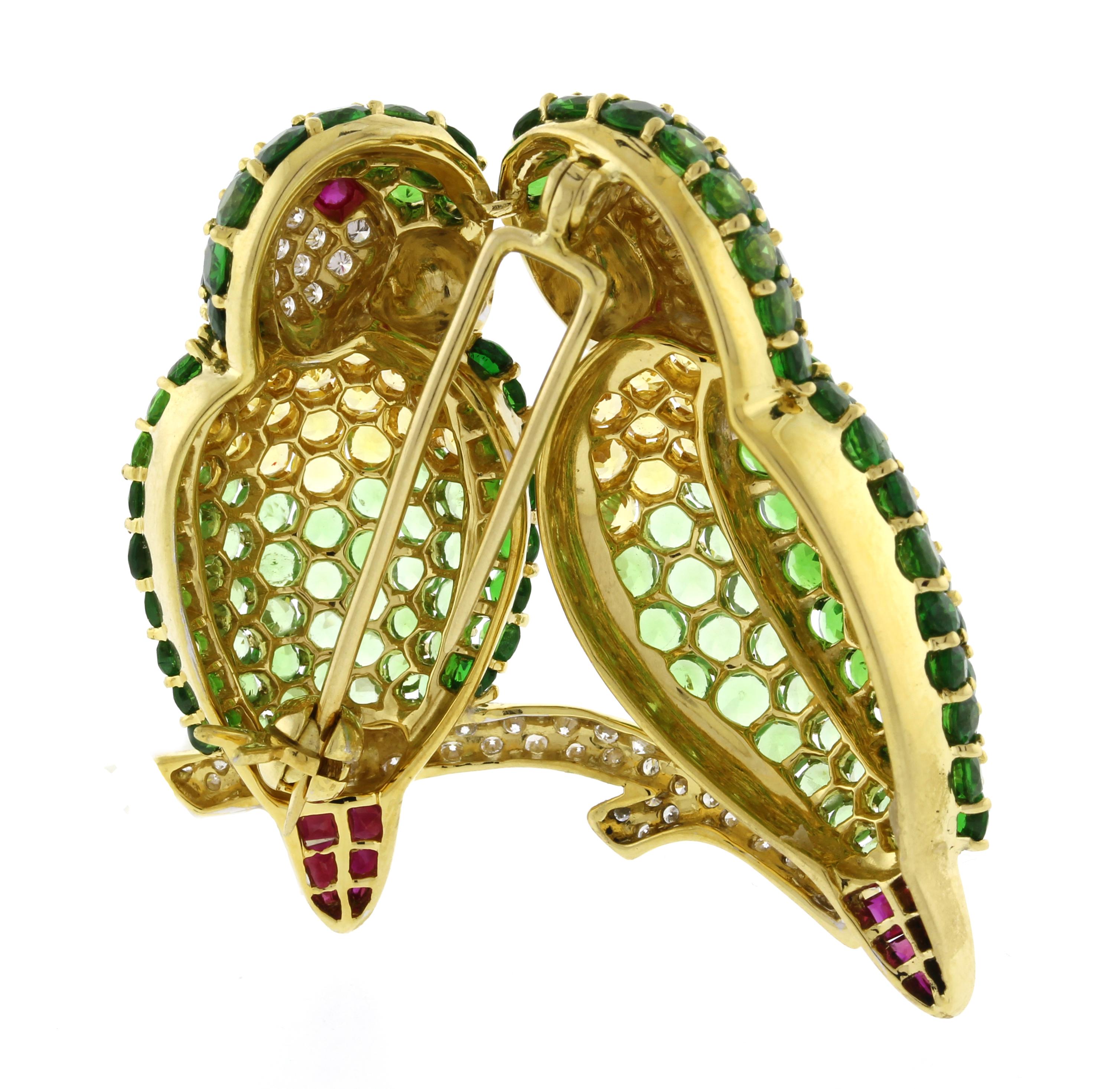 This brooch was meticulously crafted with attention to detail using an array of gemstones including diamonds, tsavorites, light green and yellow sapphires, and rubies.
♦ Metal: 18 Karat Yellow Gold
♦ Circa 1990s
♦ Gemstone approximate weights: