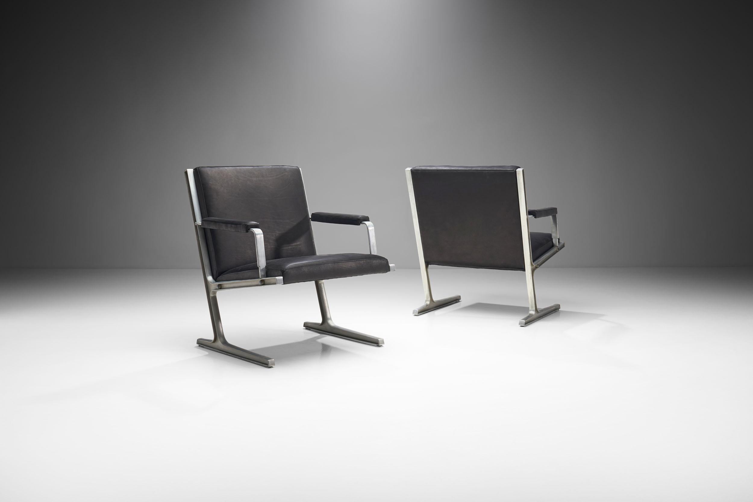 This pair of armchairs from the “Series 186” is also known as the “Lufthavns-stole” (Airport chairs). The model was designed in 1969 for Cado Collection. 

The aluminium frame is without a doubt the most dominant feature of these chairs. The