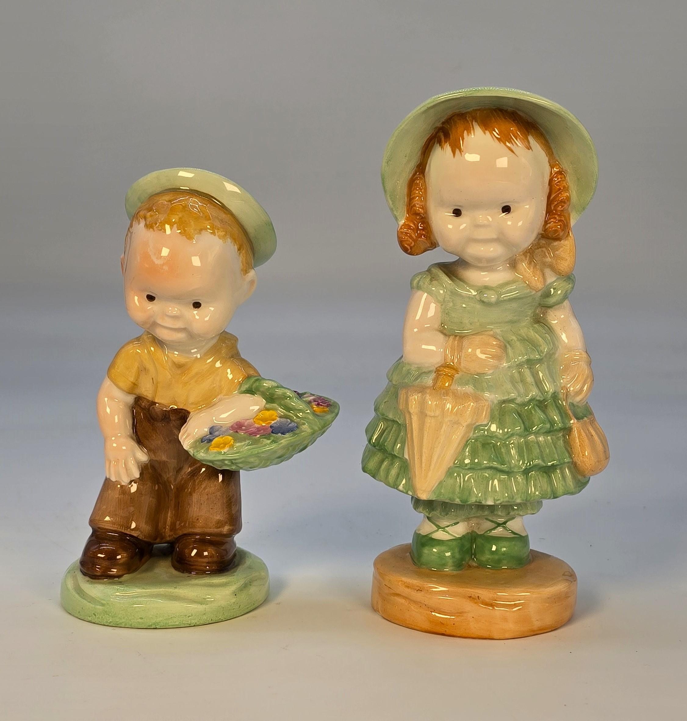 Ein sehr seltenes Paar Shelley-Porzellanfiguren: ein frecher Junge mit Hut und Blumenkorb und ein Mädchen mit hübschem Kleid und passender Haube, das einen Regenschirm und eine Handtasche trägt. Beide wurden von der berühmten englischen Künstlerin