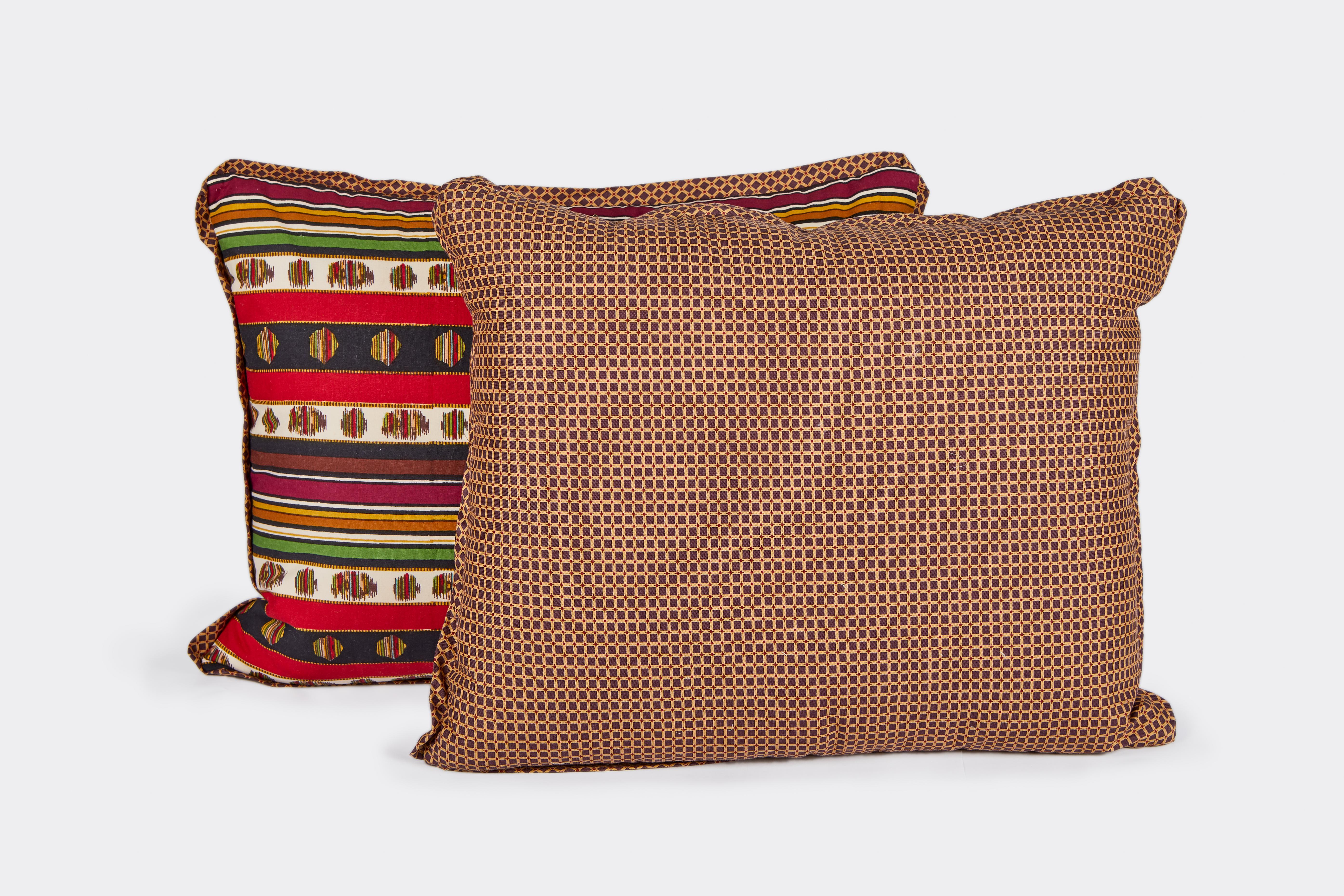 A pair of colorful lumbar cushions made with vintage Madeleine Castaing printed cotton fabric in a striped pattern, based on a 19th century document textile. The fabric on the back is a woven cotton blend. Cushions use vintage fabric, but are newly