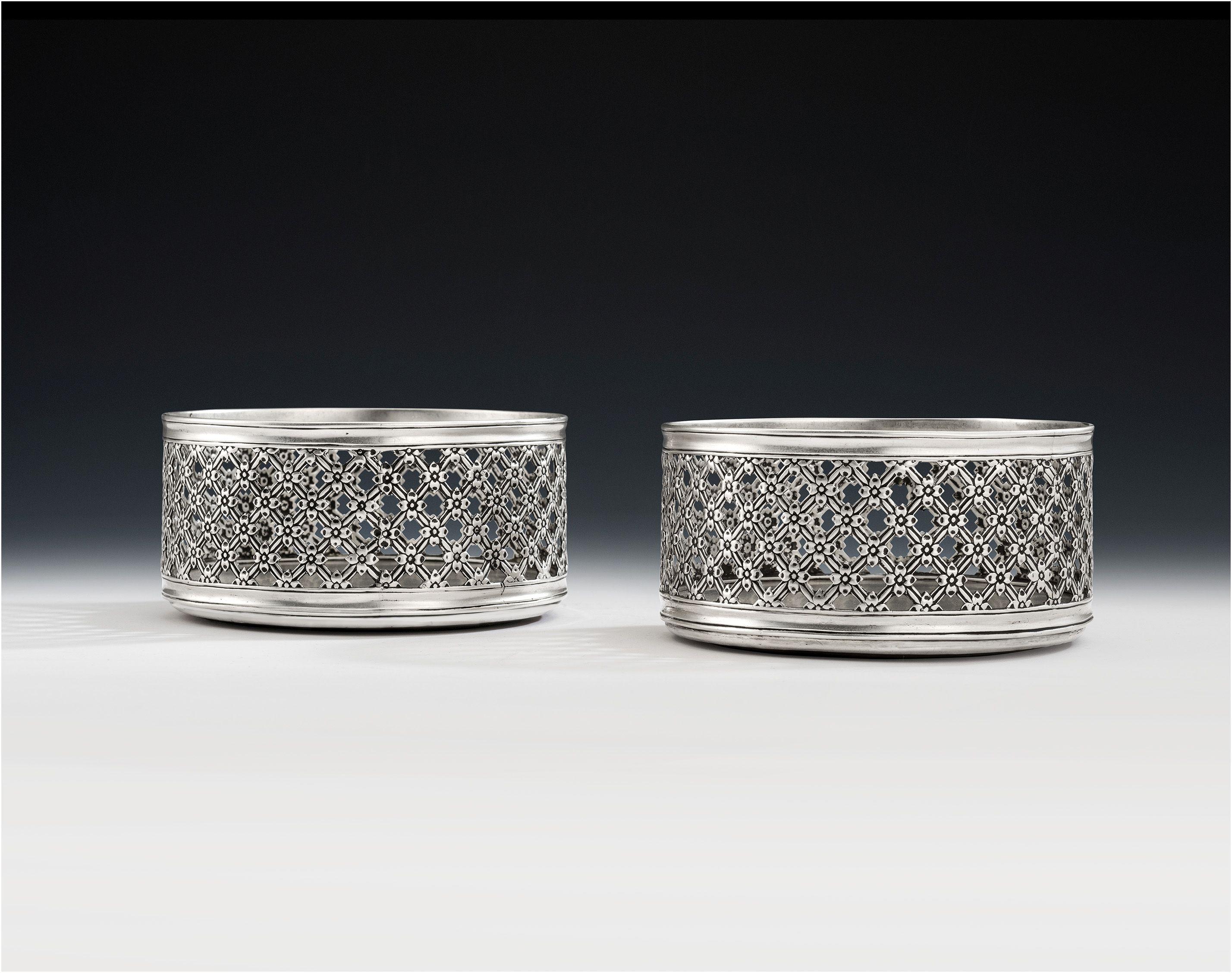 This exceptionally rare and unusual pair of floral trellis work silver based magnum wine coasters were made in London in 1852 by Daniel & Charles Houle. Both pieces are of a large size, with deep sides and plain silver bases. The sides are pierced