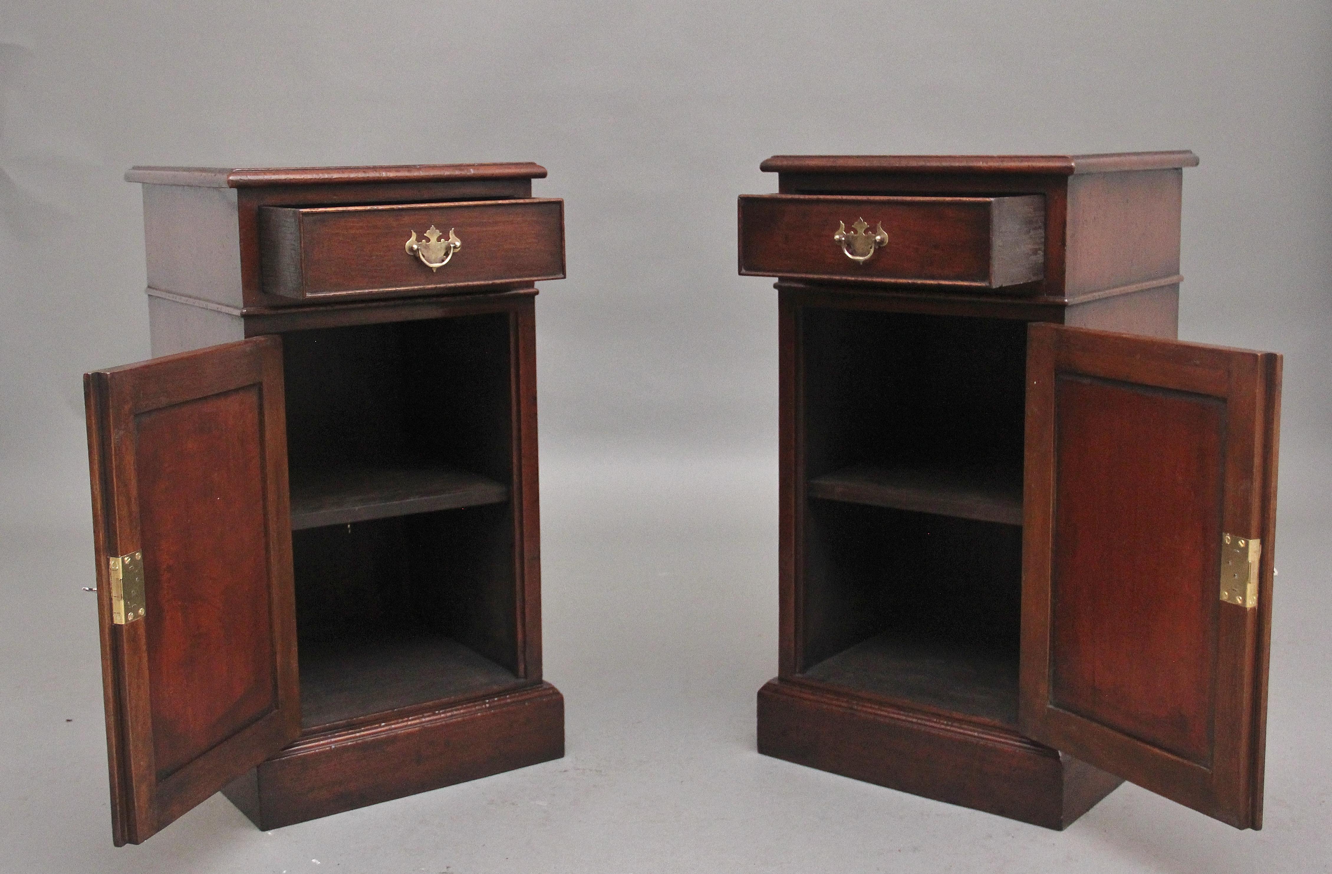 A pair of mid 20th Century mahogany bedside cabinets, having a nice figured and moulded edge top above a single drawer with a brass plate handle, cupboard below with a paneled door opening to reveal a single shelf inside, supported on a deep plinth