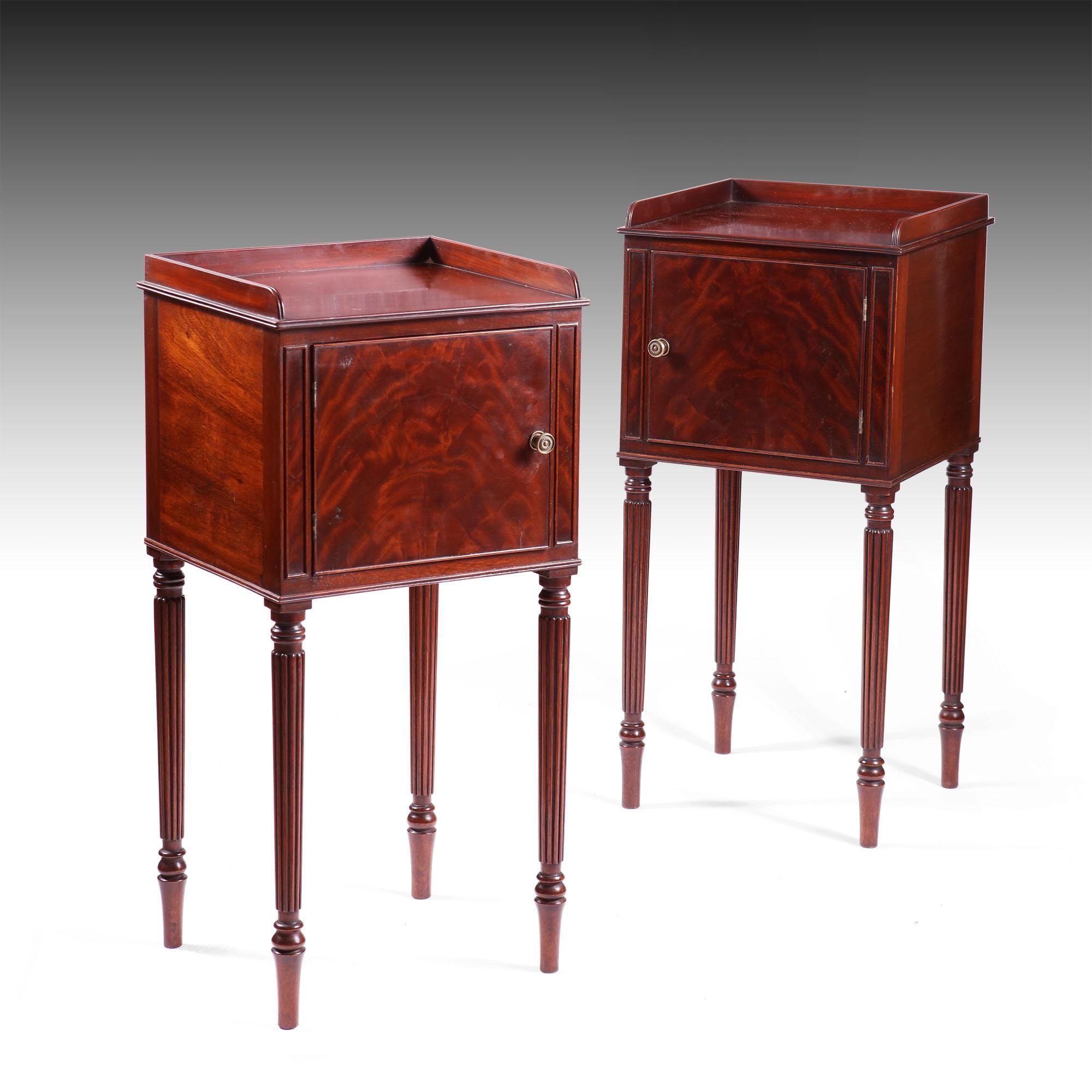 A fine pair of mahogany bedside cabinets in the manner of Gillows with typical reeded tapering legs supporting bodies with a single door and veneered with flame mahogany. 
England, circa 1900 
Measures: 15 ins wide 38cm
13 ins deep 33cm
31 ins