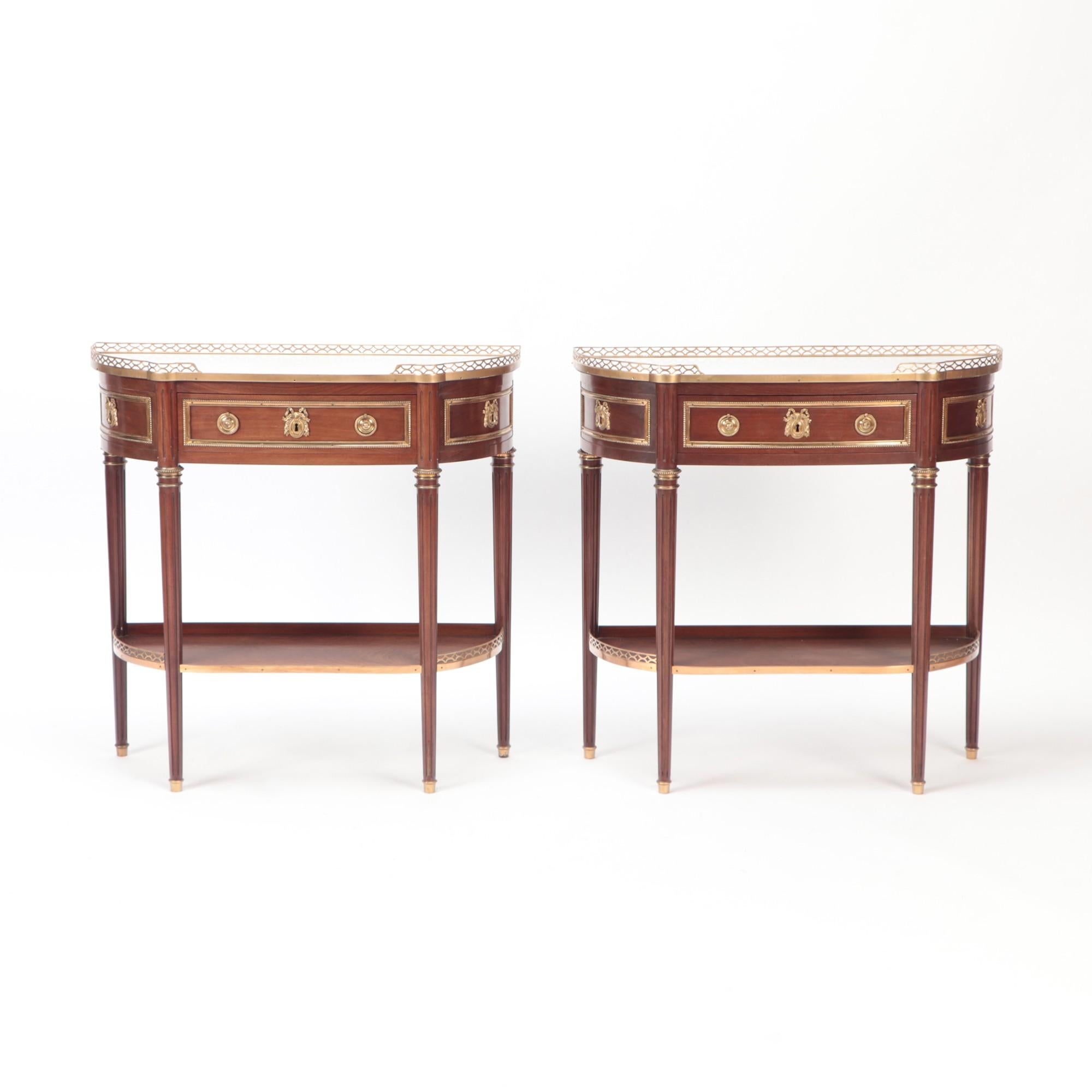 A pair of mahogany console tables with marble tops and bronze mounts in the Directoire style C 1940. Each having a single drawer and oak secondaries.
 