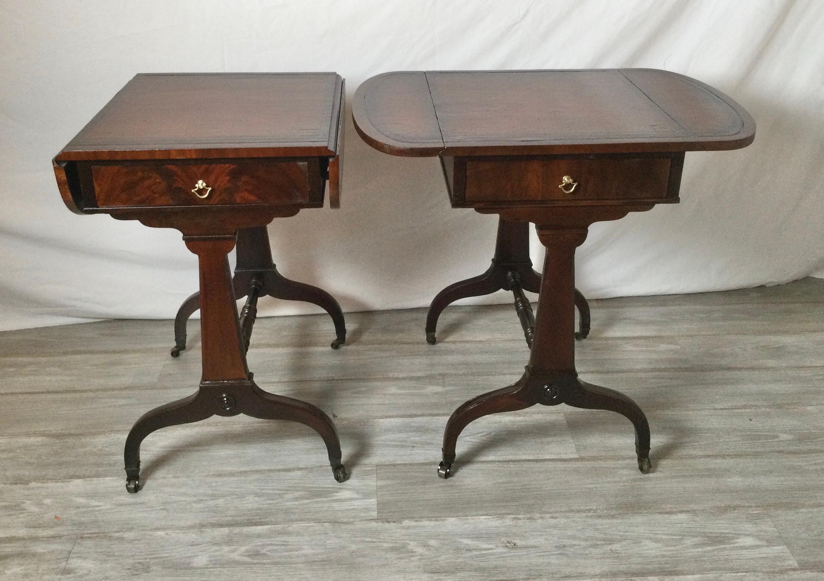 A pair of smaller Hepplewhite style flame mahogany side tables with leather tops. The finish has been refreshed and touched up with a French polish. The tables open are 27.5 wide, closed 17 inches. 20 inches deep, 26 inches tall.