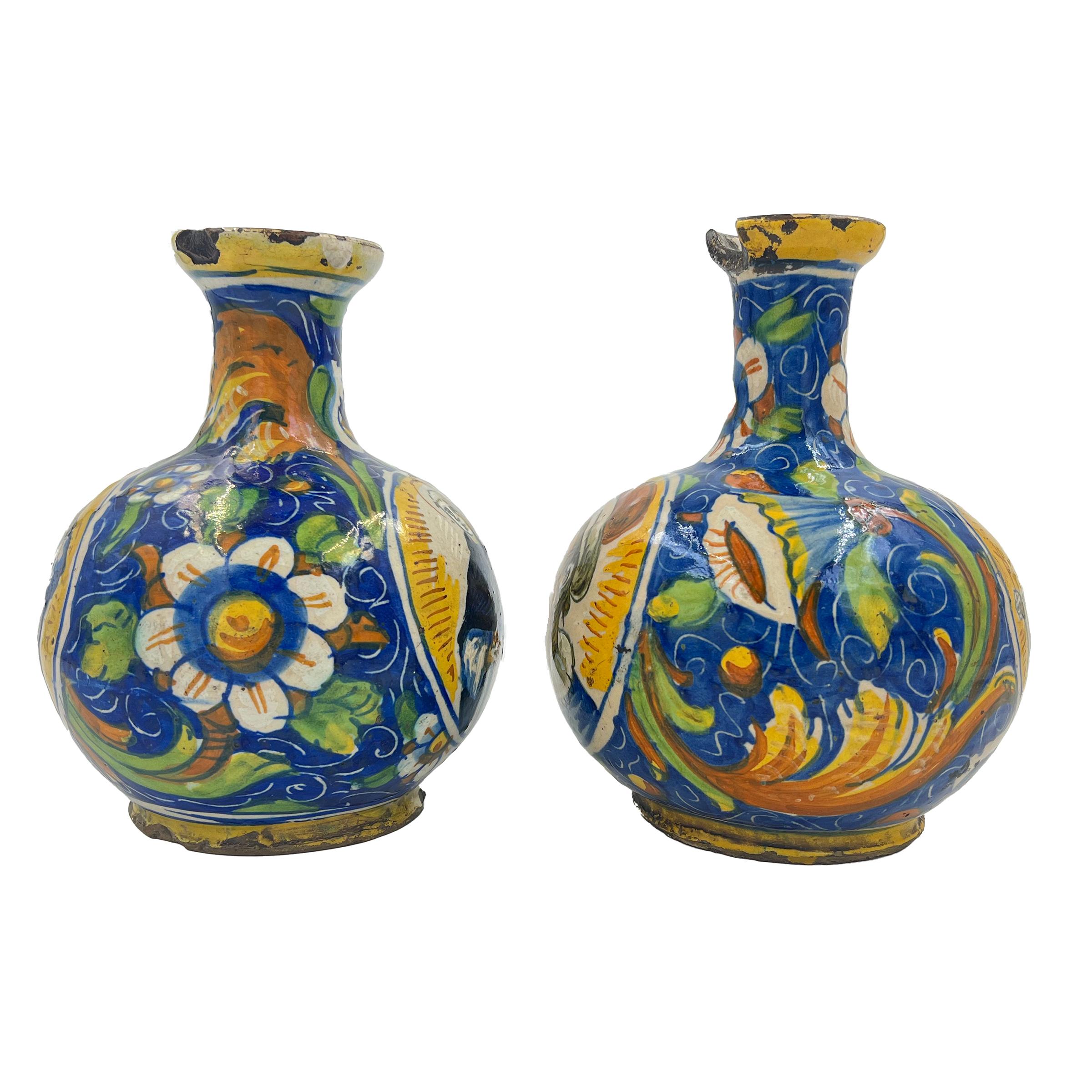 Une belle paire de vases en maïolique, peints sur un côté d'une figure religieuse et au revers d'un portrait, les côtés décorés de grandes fleurs traditionnelles entourées de rinceaux jaunes sur un fond bleu.
 