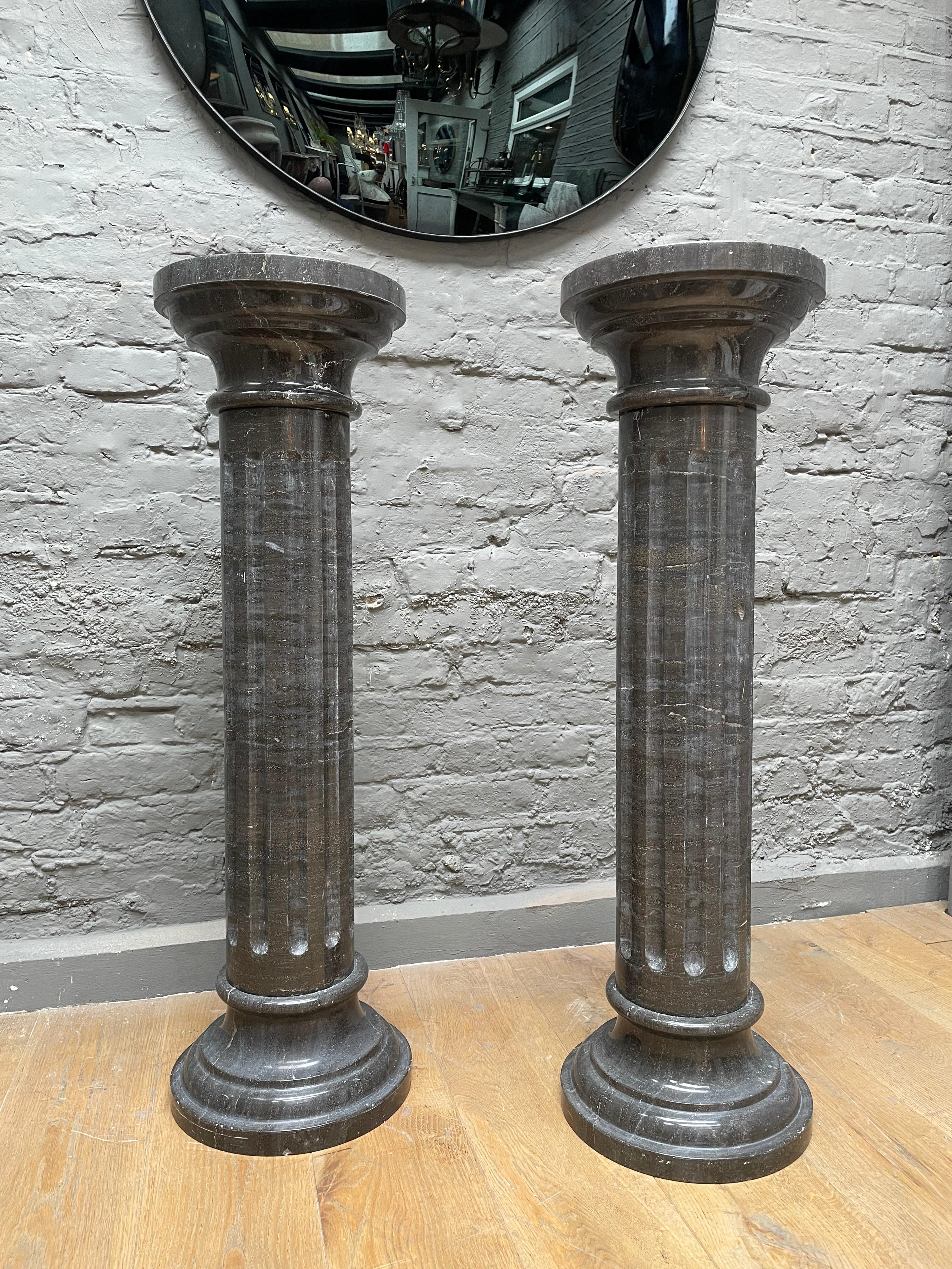 A quality pair of columns in fossil marble. The circular socle bases with fluted columns and conforming circular capitals. Each piece breaking down to socle, column and capital. Well made and in quality fossil marble,

Late 20th century.