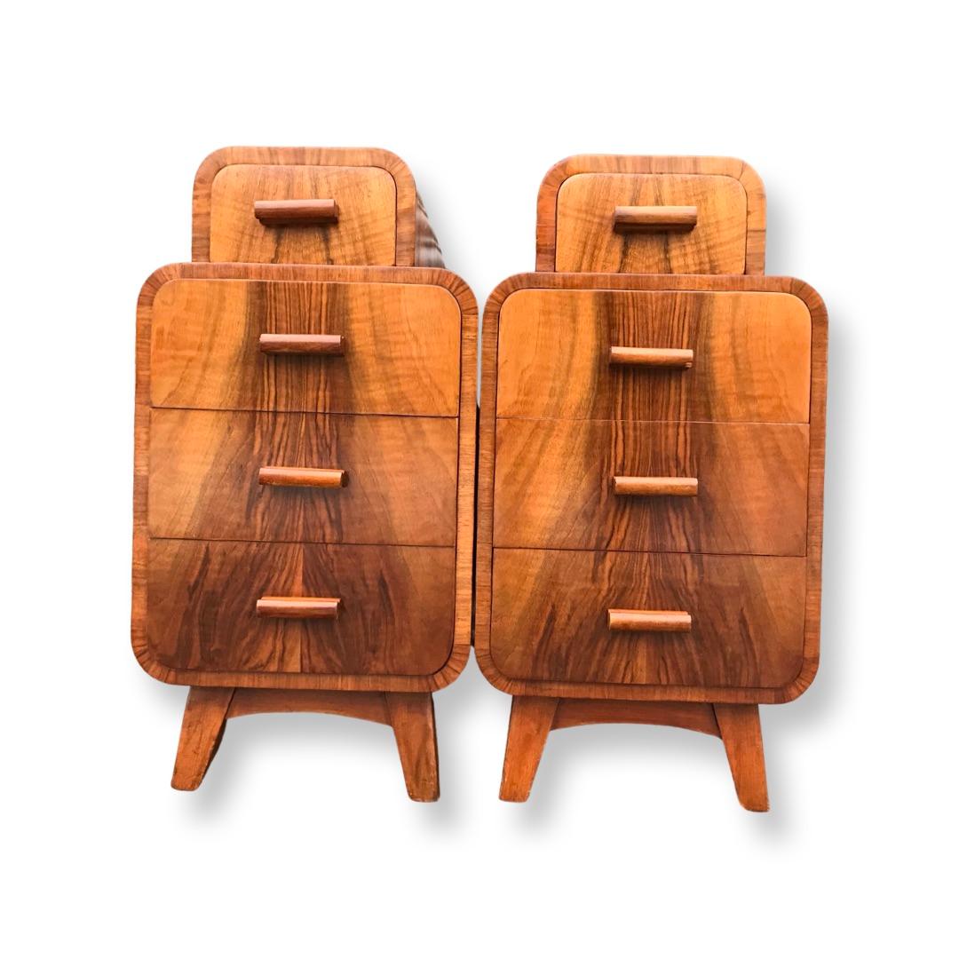 Magnifique paire de tables de chevet en noyer figuré Art Déco des années 1930. Relevés sur des pieds évasés, ils comportent quatre tiroirs dont les contours s'adaptent aux courbes du meuble. Tous les tiroirs fonctionnent très bien et sont doublés de