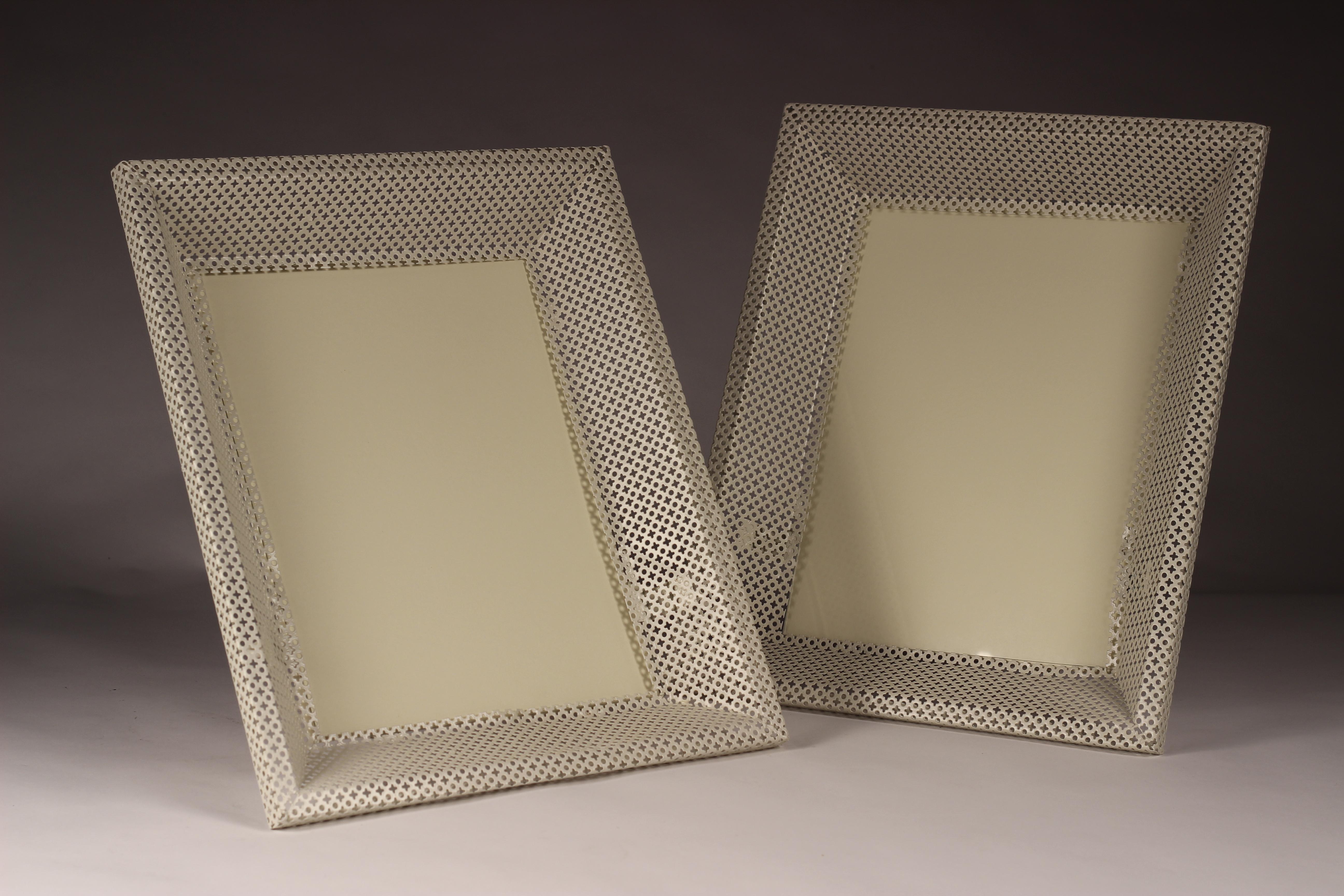 Made in the 1950s of enameled steel perforated in a pattern with Matégot's distinctive trefoil motif, this pair of freestanding picture frames or mirrors are very rare. In restored condition with glass and cardboard inserts. 

Considered one of