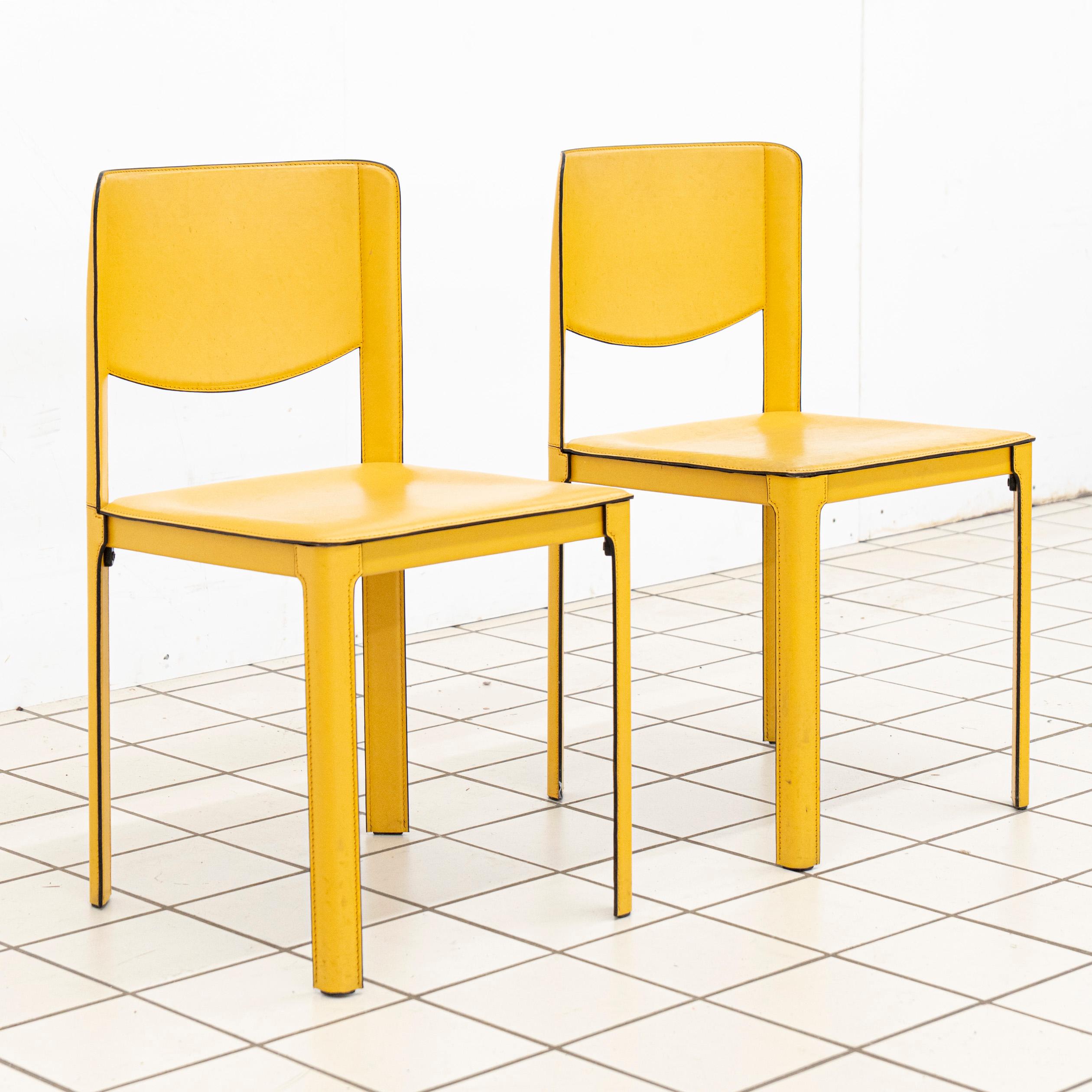 Ein Paar senfgelbe rechteckige Lederstühle von Matteo Grassi, entworfen von Tito Agnoli.
Dieses Paar ist ein Beispiel für die raffinierte, schlichte Eleganz, für die Tito Agnoli bekannt ist. Die Stühle zeichnen sich durch klare geometrische Linien,