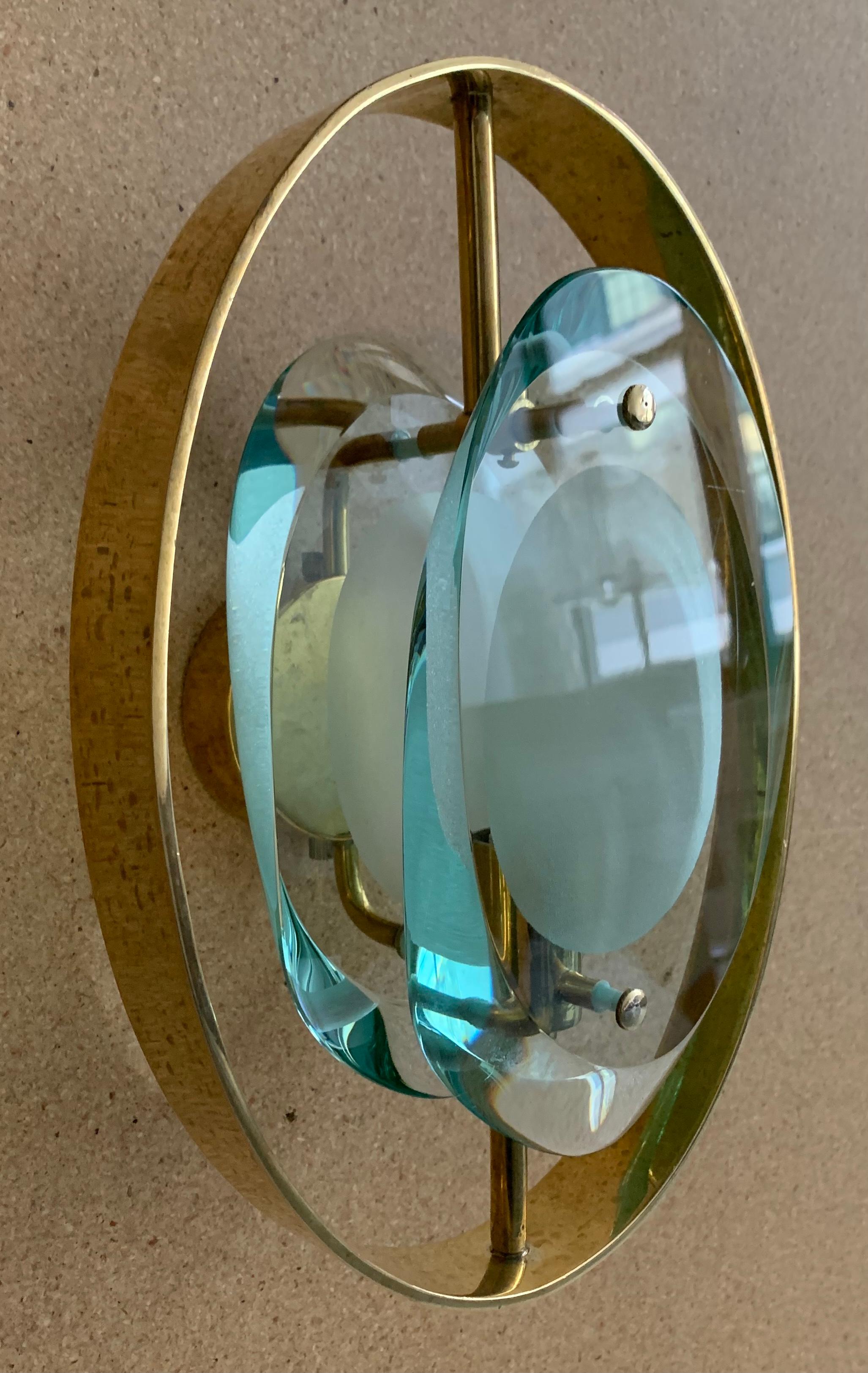 Élégante paire d'appliques réalisée par l'un des meilleurs directeurs de Fontana Arte, Max Ingrand. Une paire rare d'appliques avec des panneaux à double lentille en verre poli profilé épais avec des centres en verre gravé et des raccords en laiton.