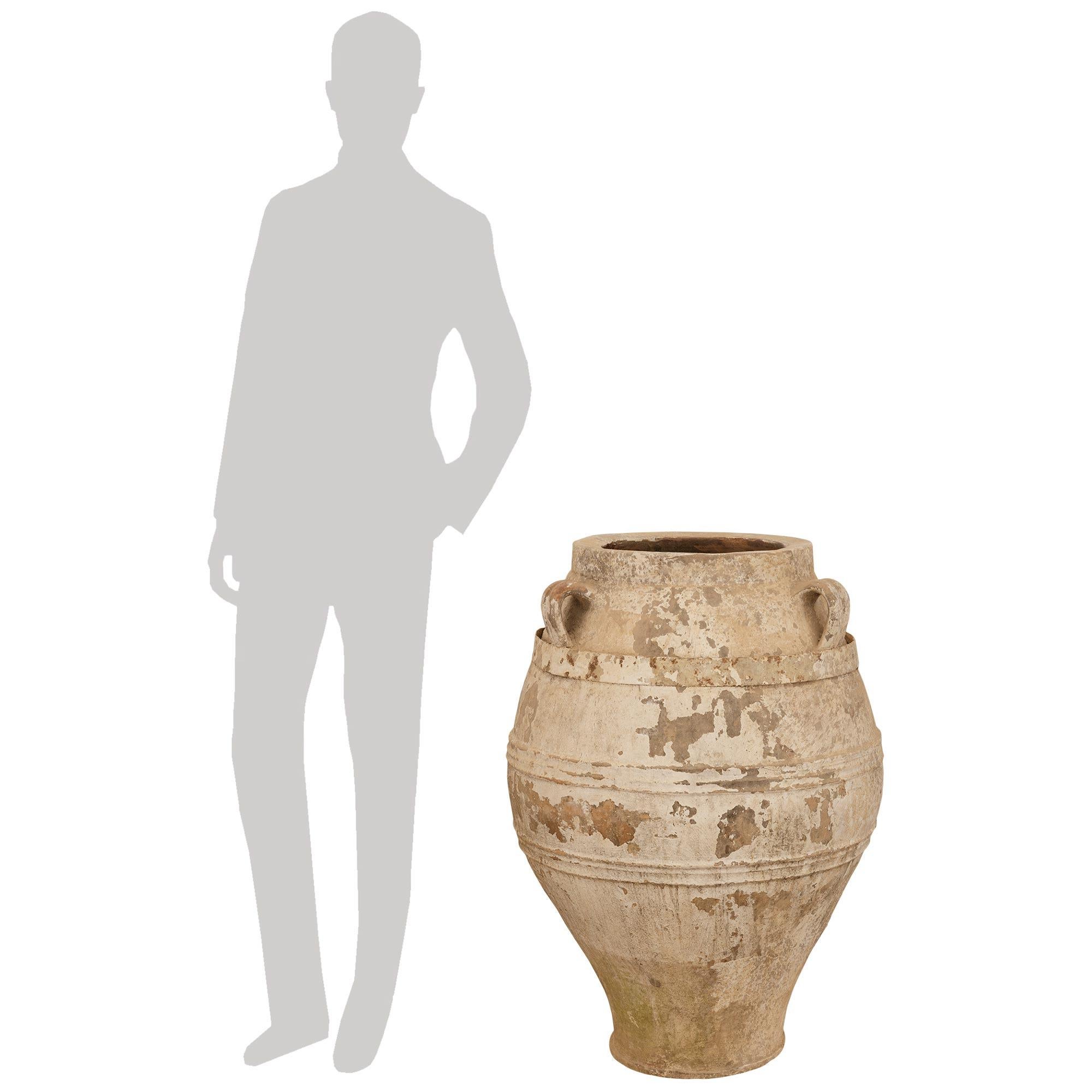 Une superbe paire de jarres à olives en terre cuite patinée du 19e siècle. Chaque jarre à olives, magnifique et extrêmement décorative, présente une forme de balustre incurvée des plus élégantes, avec trois anses en volute au-dessus et une patine
