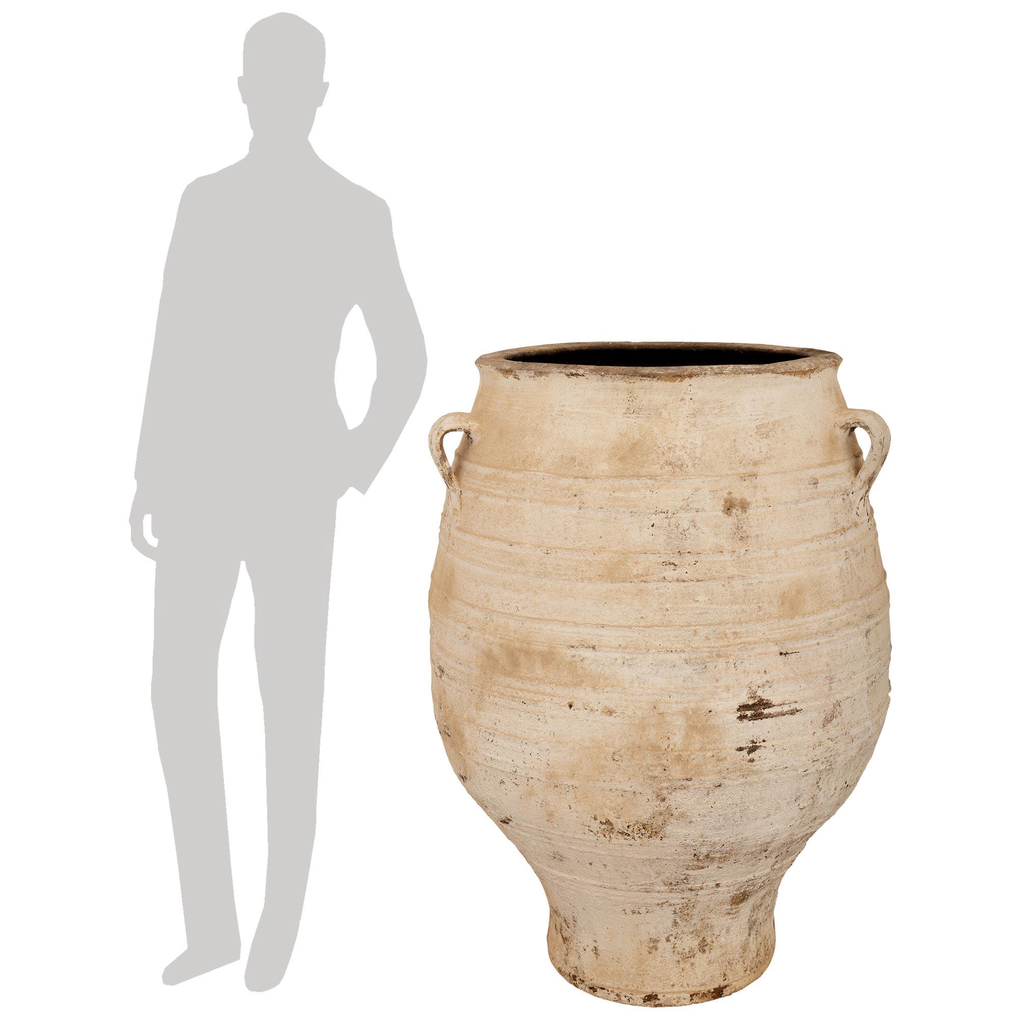 Una coppia elegante e molto decorativa di vasi per olive in terracotta patinata del XIX secolo. Ogni vaso di olive, bellissimo ed estremamente decorativo, presenta un'elegantissima forma a balaustro curvo con tre manici a voluta sopra e tutta la