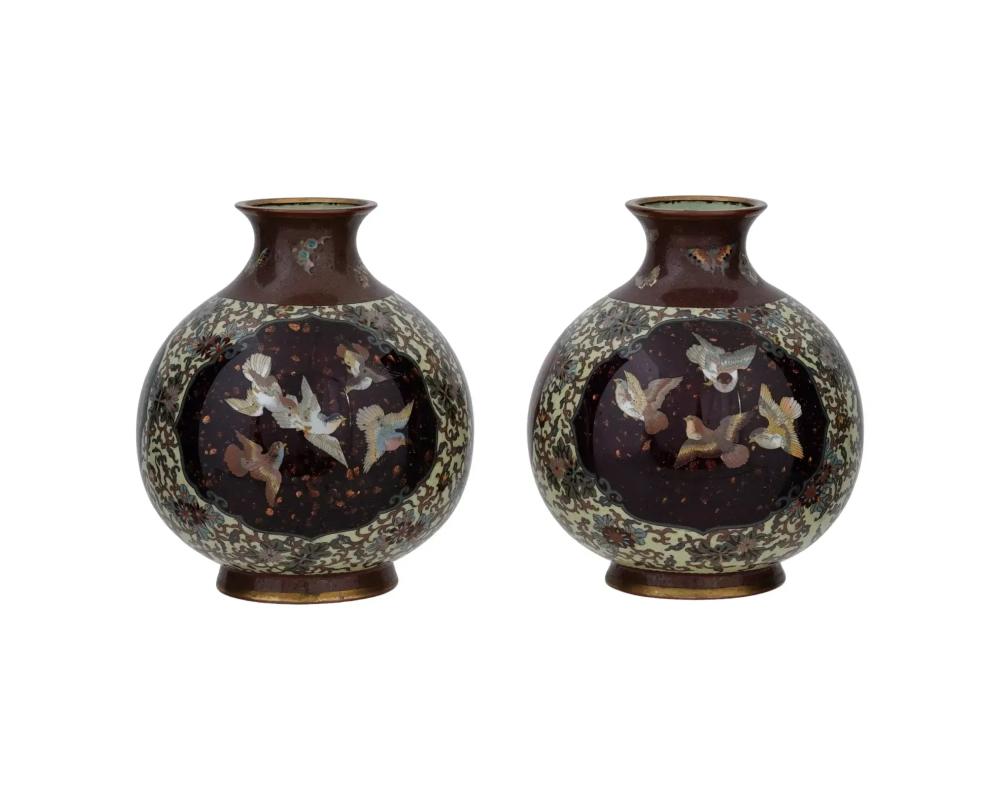 A pair of high quality Japanese Meiji period cloisonne enamel vases, each of a globular form with a short flared neck with an everted rim, decorated with stylized floral patterns and featuring three goldstone ground roundels with cloisonne enamel
