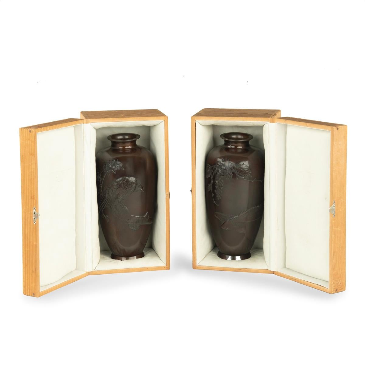 Zwei Bronzevasen aus der Meiji-Periode mit Hochreliefdekor, eine mit einem Fasan auf einem Prunusblütenzweig, die andere mit zwei Karpfen, die unter einem Zweig mit Glyzinienblüten schwimmen, signiert Hidemitsu kansei/ Shuko kansei.  Japanisch, um