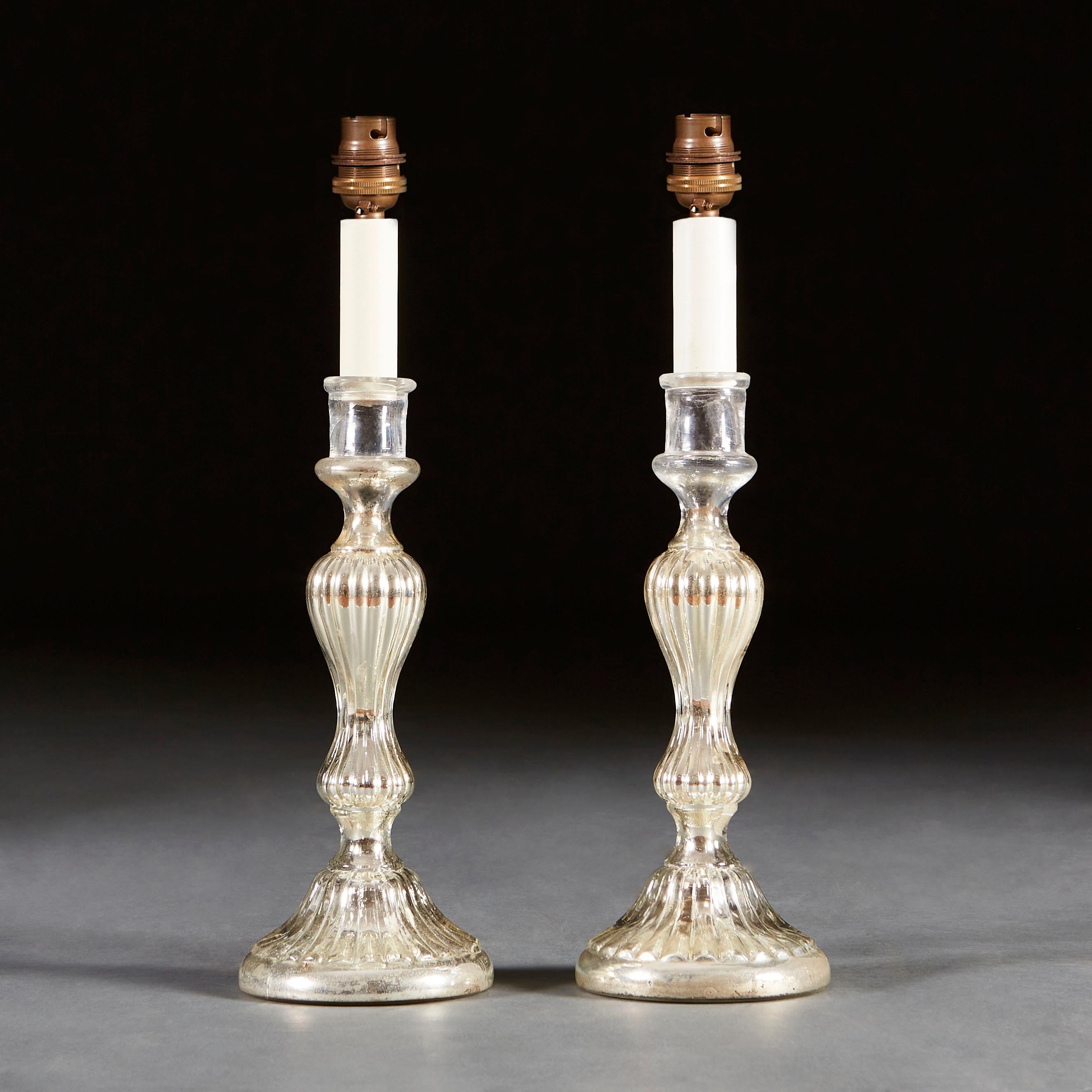 A pair of mercury glass candlesticks with gadrooning and shaped stems, supported on circular bases, now as lamps.

Currently wired for the UK. Please enquire for rewiring services.

Please note: lampshades not included.