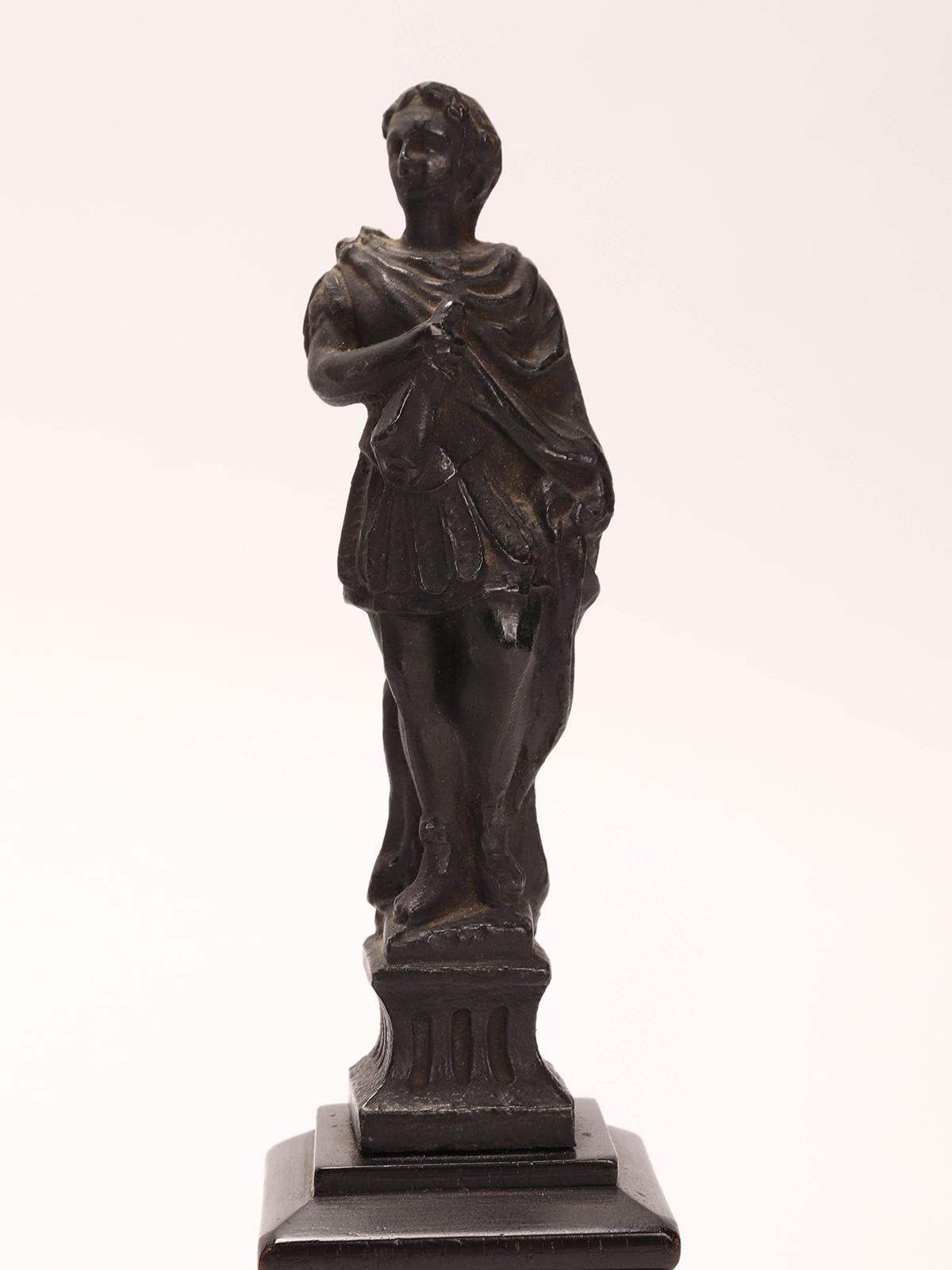 Italian Grand Tour: a pair of little white metal (bronze finishing patina) sculptures, depicting a figurine of a roman legislator and a roman warrior, mounted on ebony wooden bases. Venice, Italy 1880 ca.
