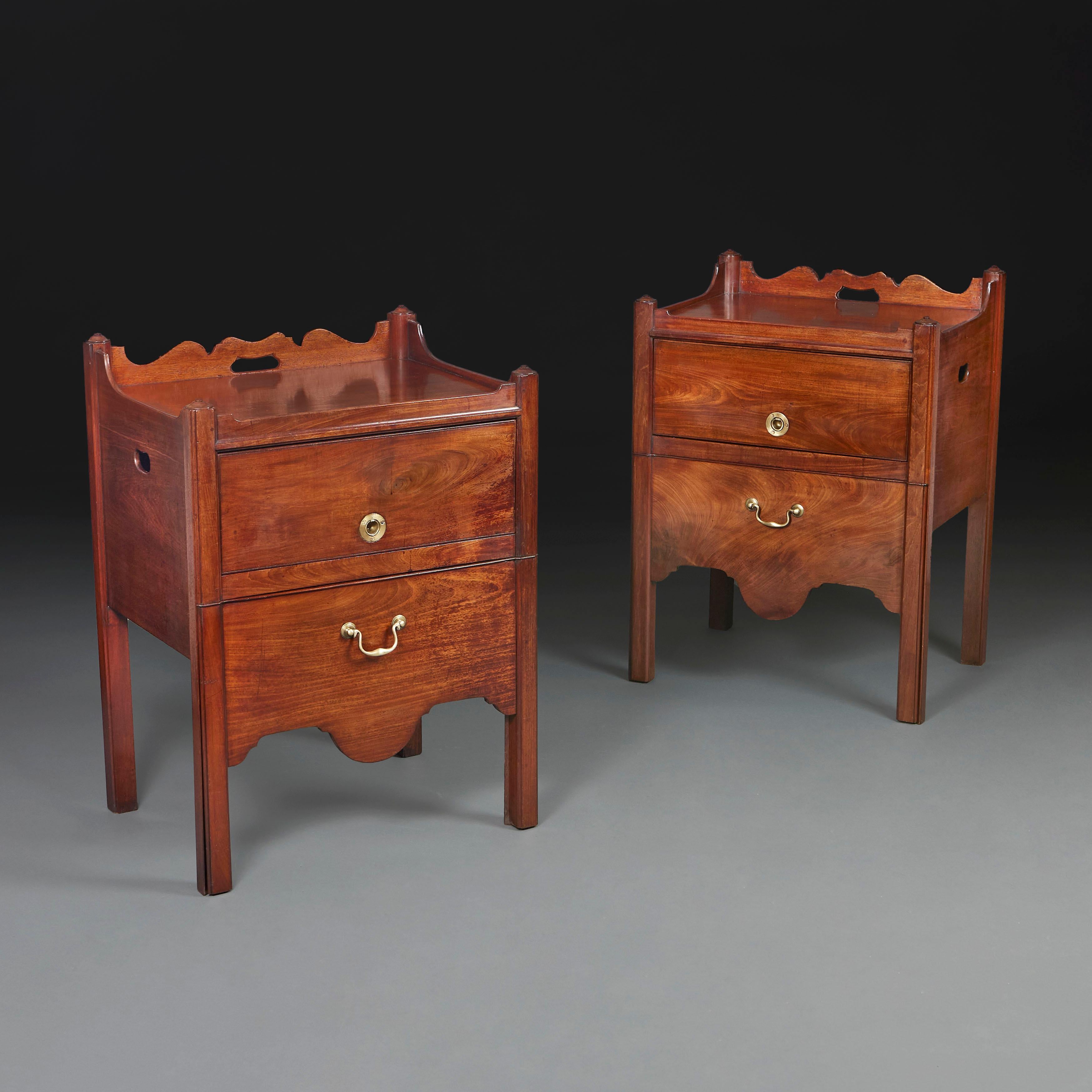 England, circa 1760

A fine pair of mid eighteenth century mahogany bedside cabinets, with shaped rails and carrying handles, the lower drawer revealing a horizontal surface, cupboard doors with ring pull handles, all supported on square legs.