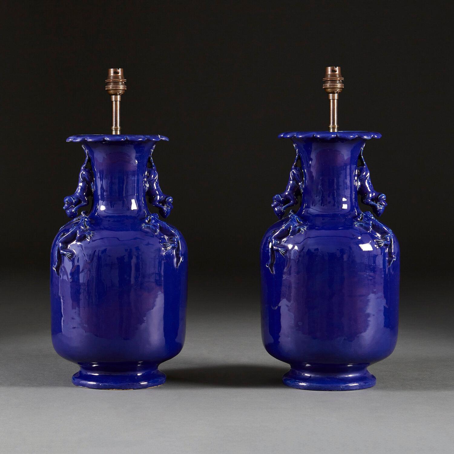 A pair of mid nineteenth century blue glaze vases with dragons to the necks, and handles to each side of the neck in the form of a dog. Now converted as lamps.

Please note that the lampshade is not included, and that the lamps are currently wired