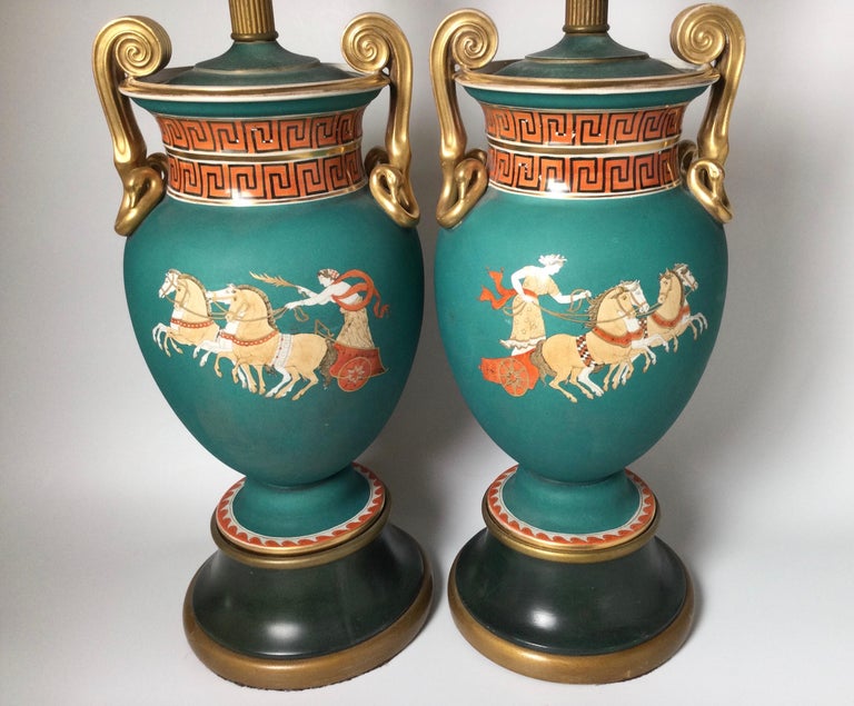 A pair of mid 19th Century French hand painted porcelain Grecian style neoclassical urns now as lamps. The vibrantly colored urns with gilt accents with Greek style cartouches on the fronts and backs. New sockets, with new lamp cords. 23 inches tall