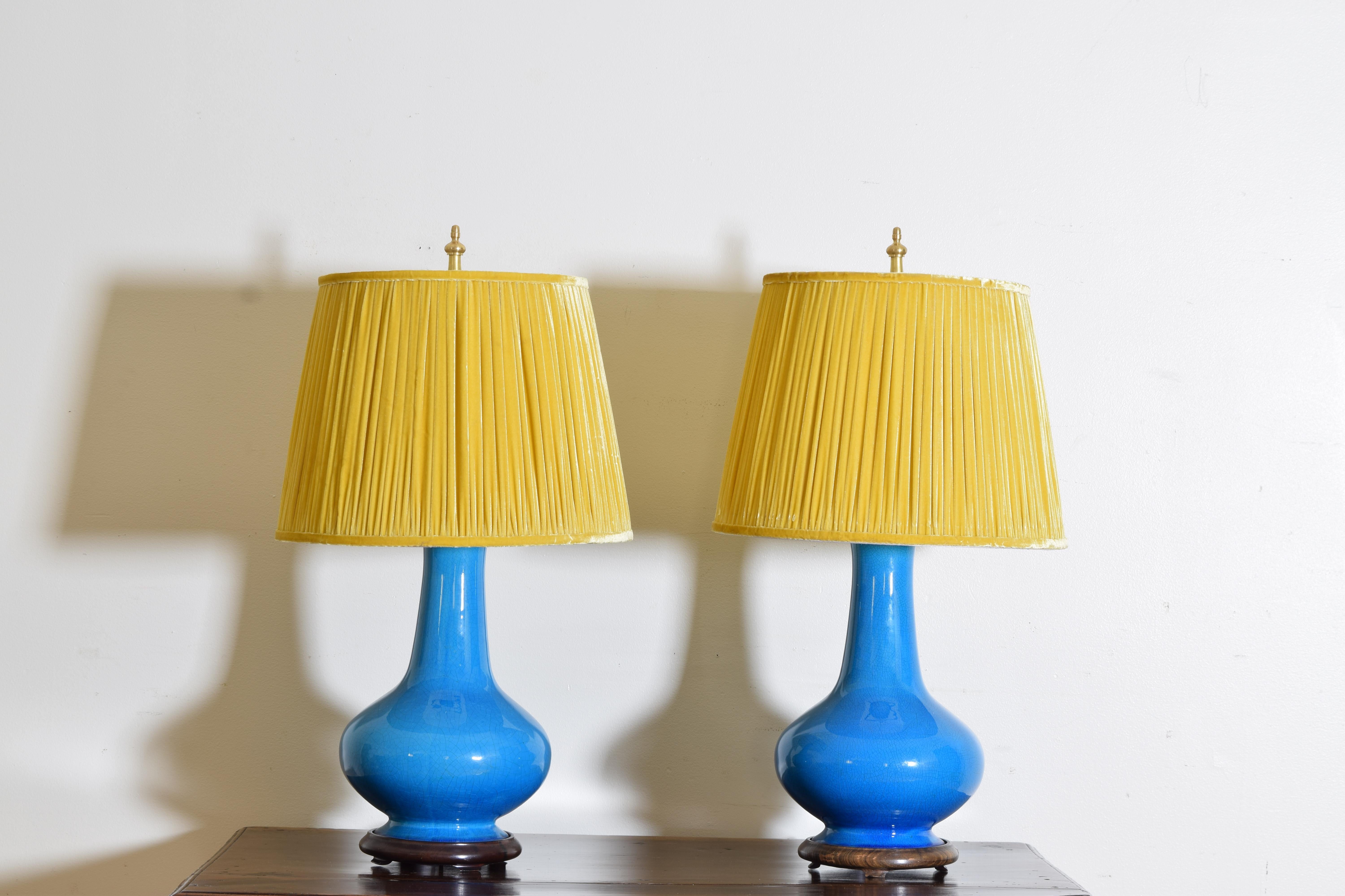 Pair of Porcelain Baluster-form table lamps beautifully glazed in a cerulean blue crackle finish. Raised on a wood base with brass hardware and harps.  The custom saffron yellow velvet pleated shades are meticulously detailed and stunning.