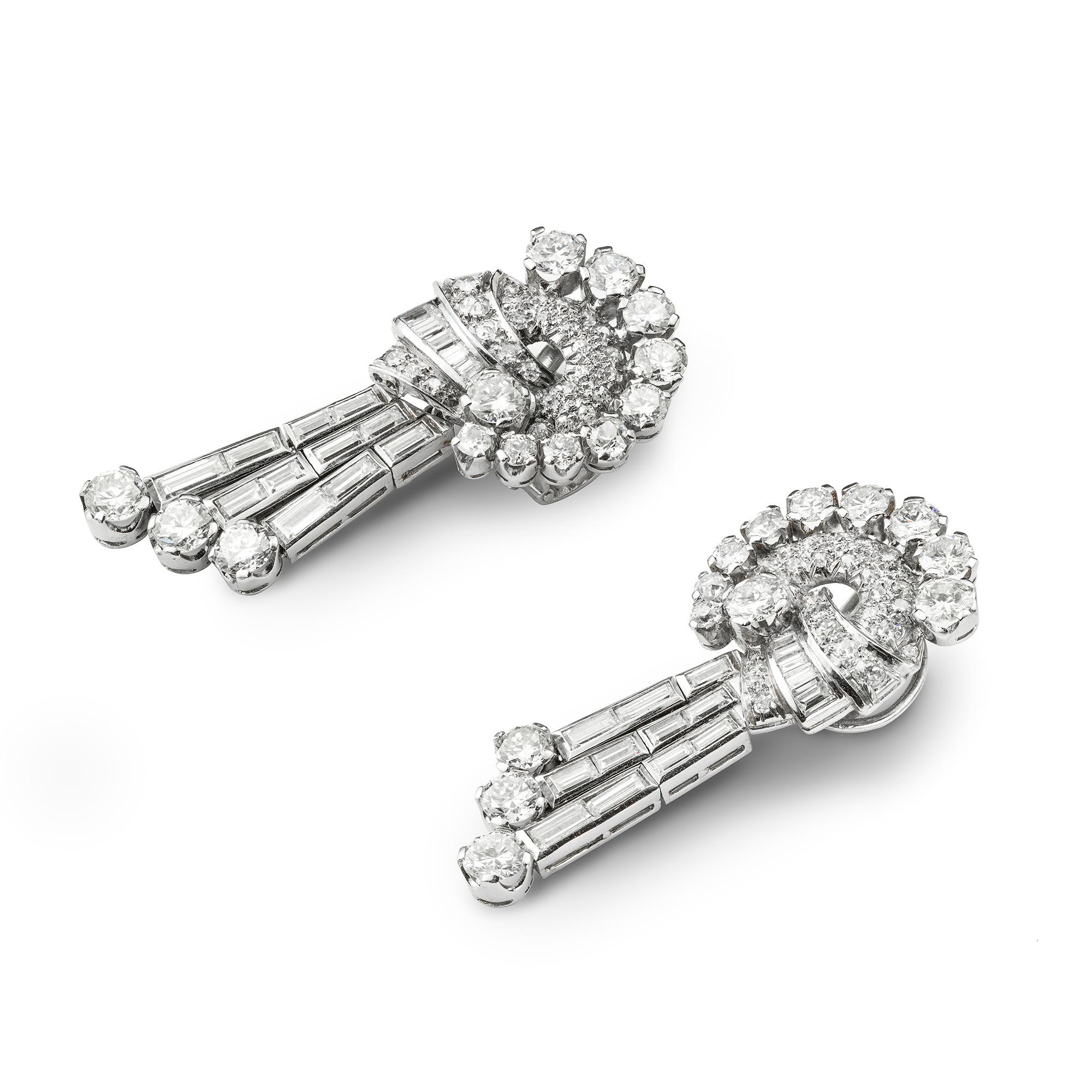 A Pair Of Mid 20th Century Diamond Drop Earrings, consisting of a triple line drop, all set with round brilliant, baguette and Swiss-cut diamonds estimated to weigh a total of 8 carats, mounted in platinum and white gold, with white gold clip
