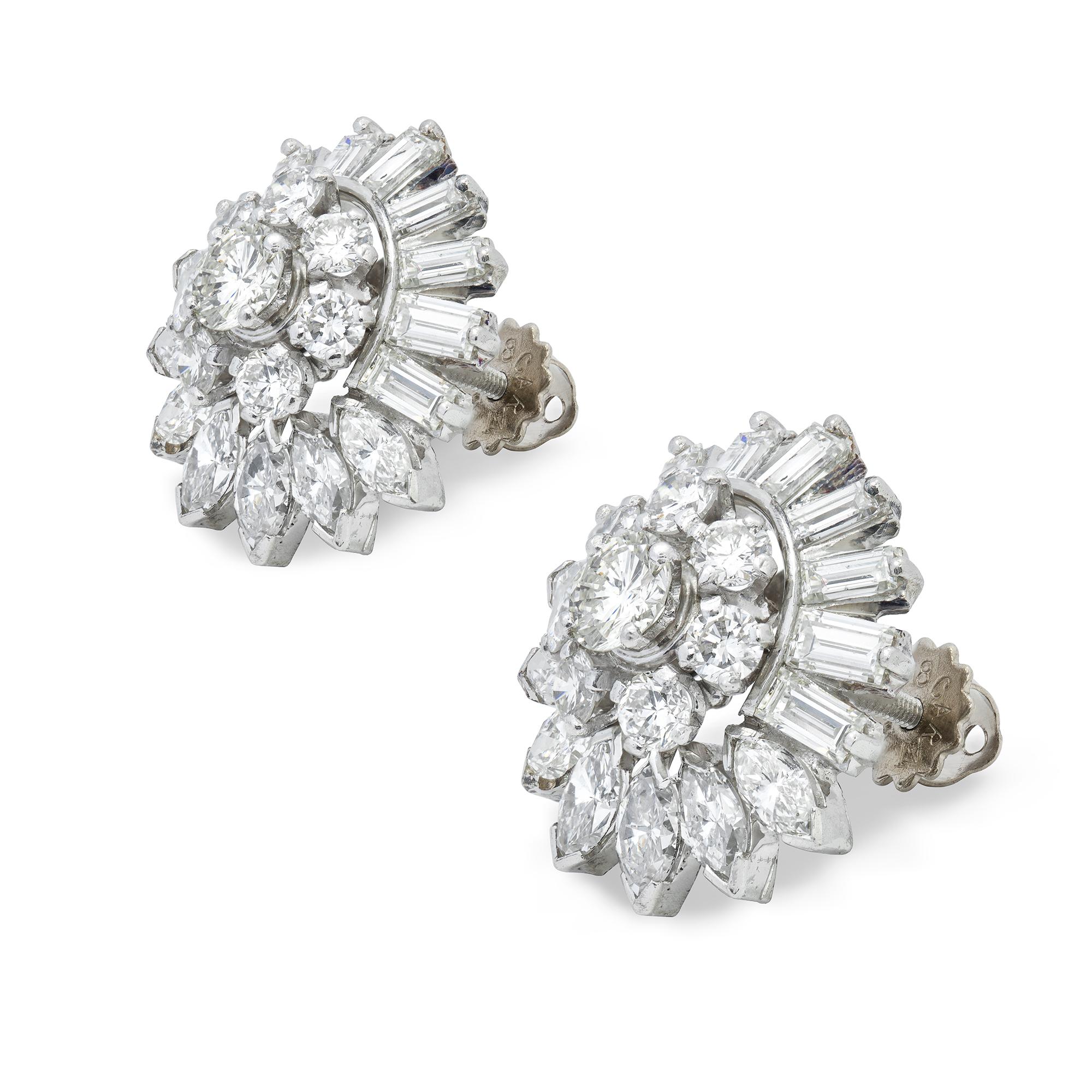 A mid-20th century pair of diamond earrings, each centre set with a round brilliant-cut diamond estimated to weigh  approximately 0.40 carat, surrounded by seven smaller round brilliant-cut diamonds, all within a cluster of seven marquise-cut and