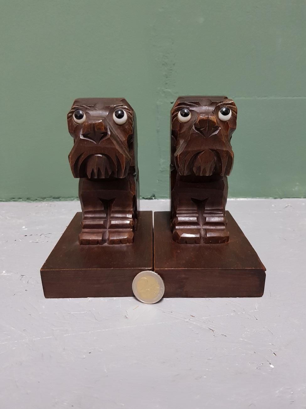 A pair of vintage hand carved wooden bookends in the shape of sitting dogs, both in good condition and made in the 1960s.

The measurements are:
Depth 9 cm/ 3.5 inch.
Width 13 cm/ 5.1 inch.
Height 15 cm/ 5.9 inch.