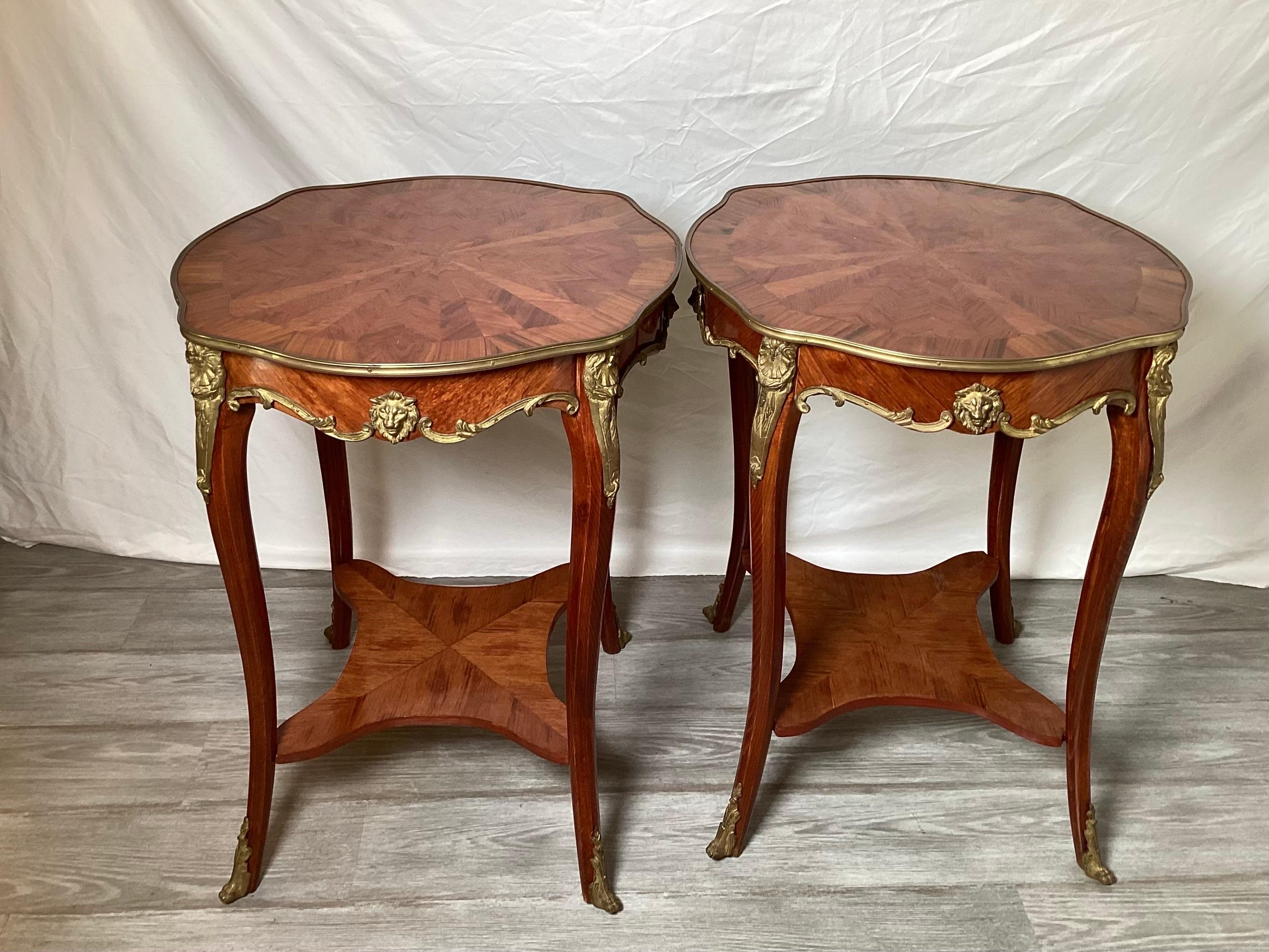 An elegant pair of Louis XV style round tables with inlays of tulipwood, kingwood and others The top and legs with gilt brass mounts with an x stretcher base.