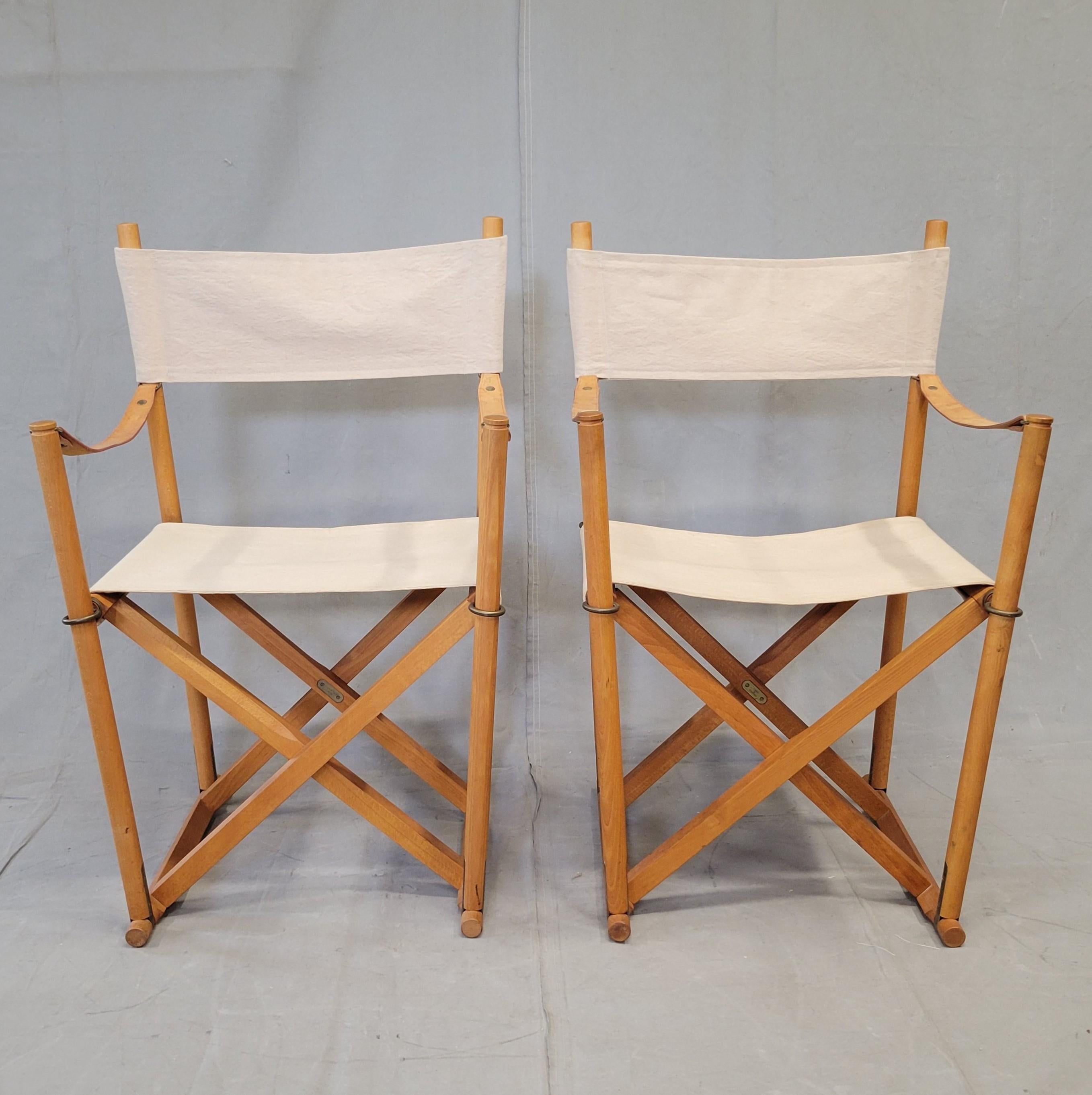 Una classica coppia di sedie safari pieghevoli Mogens Koch by Cado MK-16 della metà degli anni '60, realizzate in legno di faggio splendidamente patinato, con finiture originali in ottone e braccioli in pelle.  Le sedie sono contrassegnate dalle