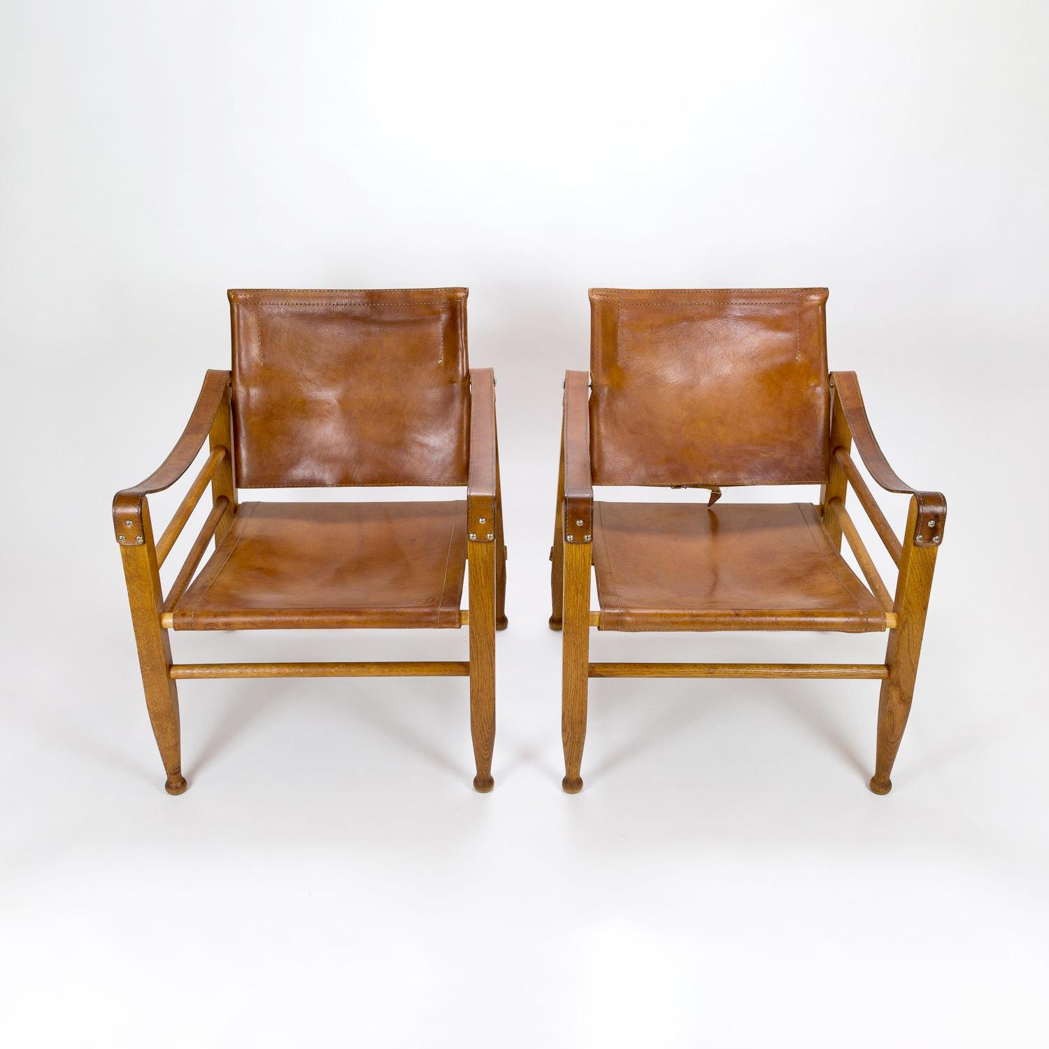 An early pair of midcentury Aage Bruun & Søn Safari chairs in patinated cognac leather and solid oak. Excellent patina. Denmark, 1960s.