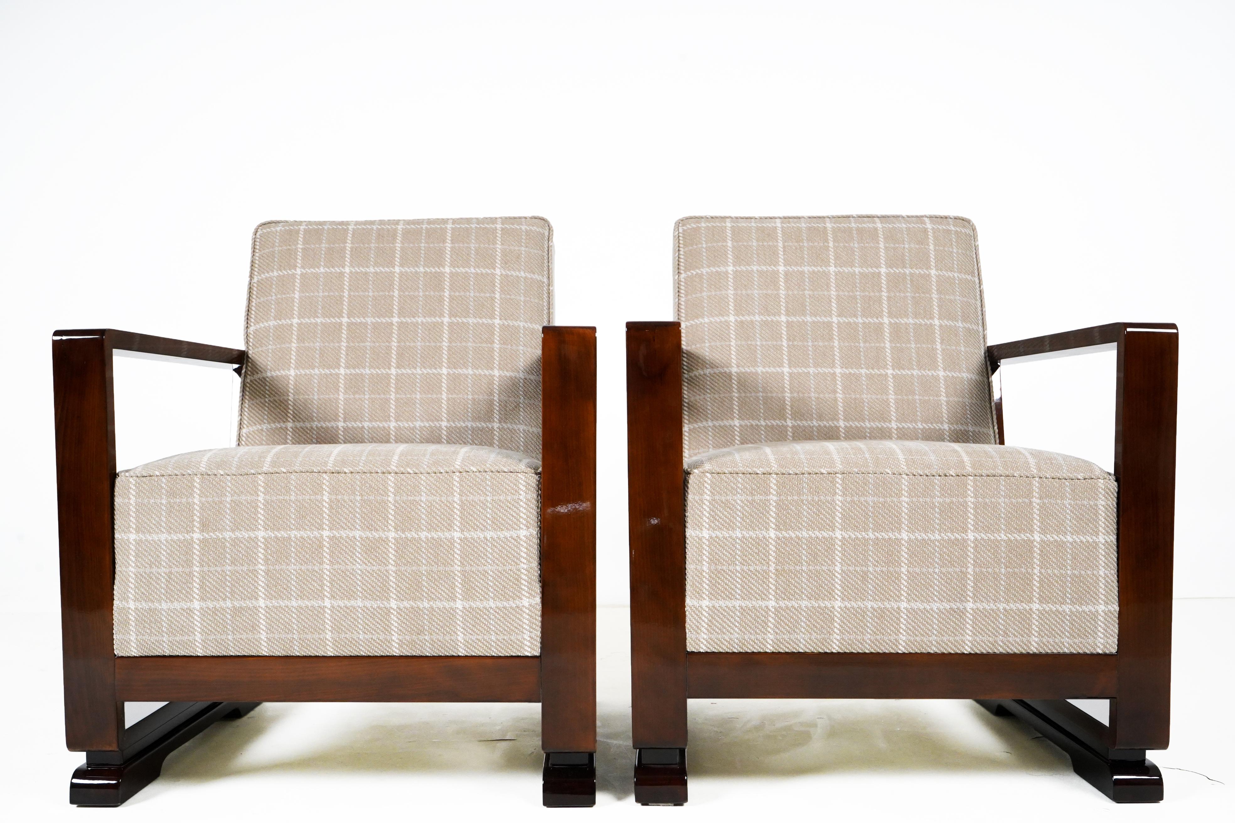 This pair of simple and starkly angular armchairs is loosely based on Art Deco originals. The arms are smoothly French-polished Hungarian walnut veneer. The upholstery is a contemporary plaid. The voluminous seats and backs provide ample cushioning