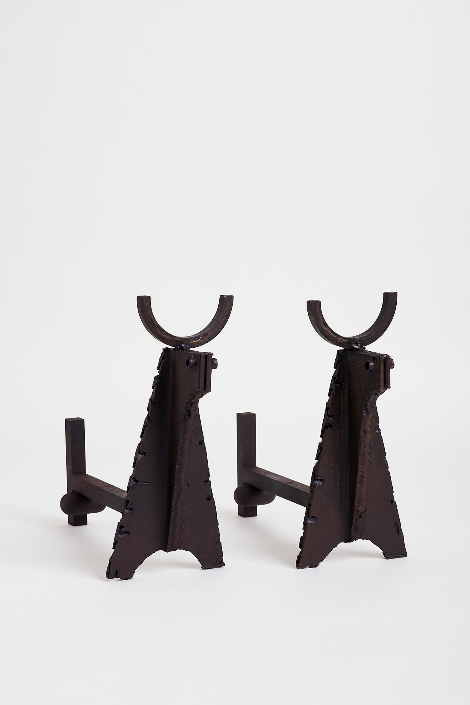 A pair of wrought iron fire dogs, depicting bulls, including their very male attributes.
France, circa 1950.