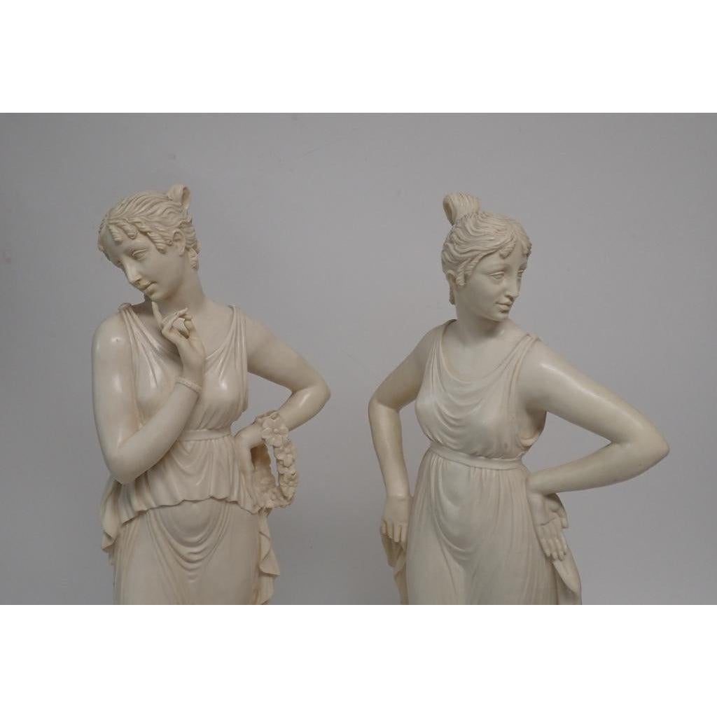 A pair of midcentury classical women sculptures. Set of two female figural composition sculptures on attached bases. Both pieces are Signed A. Santini and initialed A.S.
