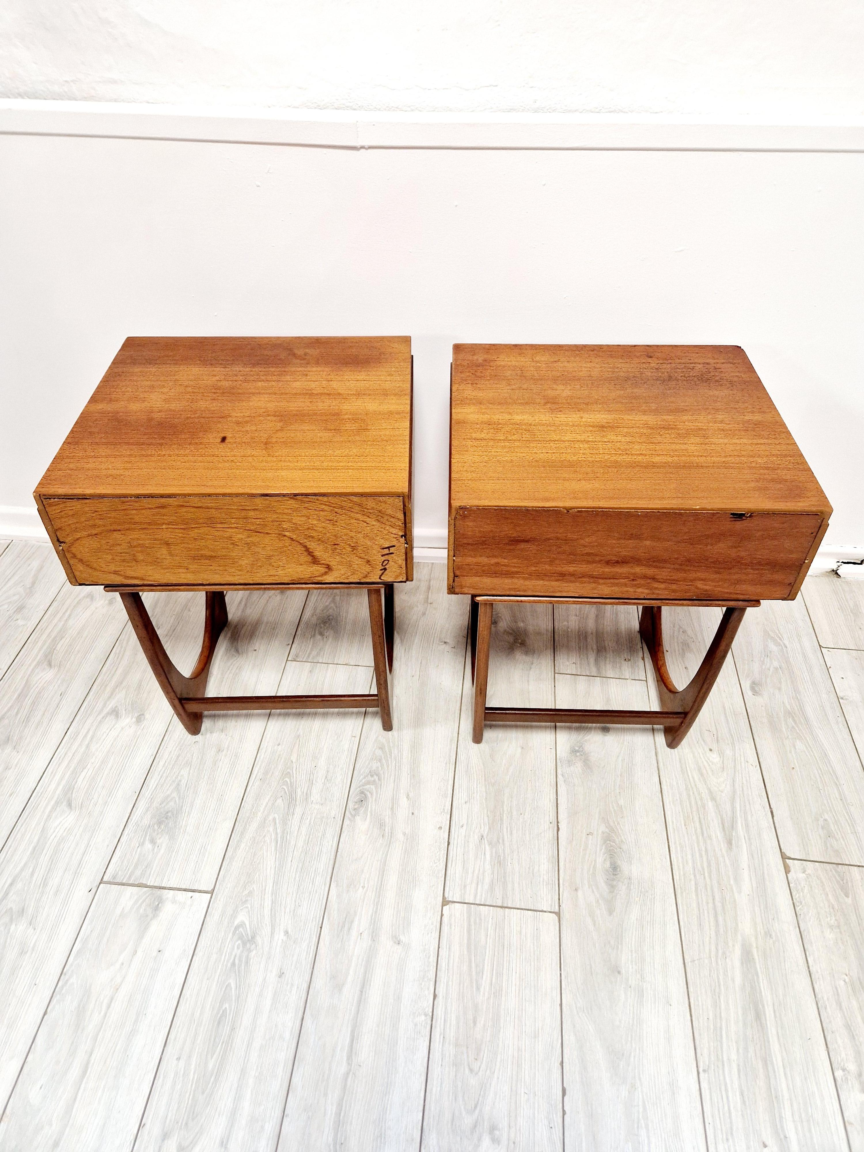 Explore the charm of mid-century design with this pair of G Plan teak bedside cabinets. Crafted in the United Kingdom during the 1960s, these cabinets exude a timeless elegance with their solid teak construction and warm medium wood tone. Perfect