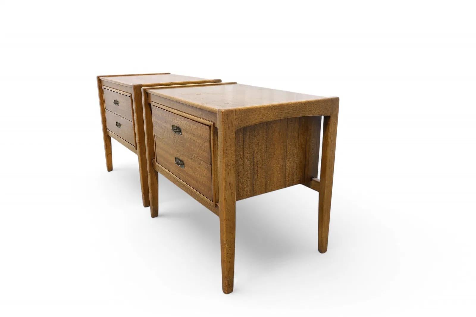 A pair of vintage walnut nightstands, by Drexel. Each nightstand includes two smooth-gliding drawers offering ample bedside storage.