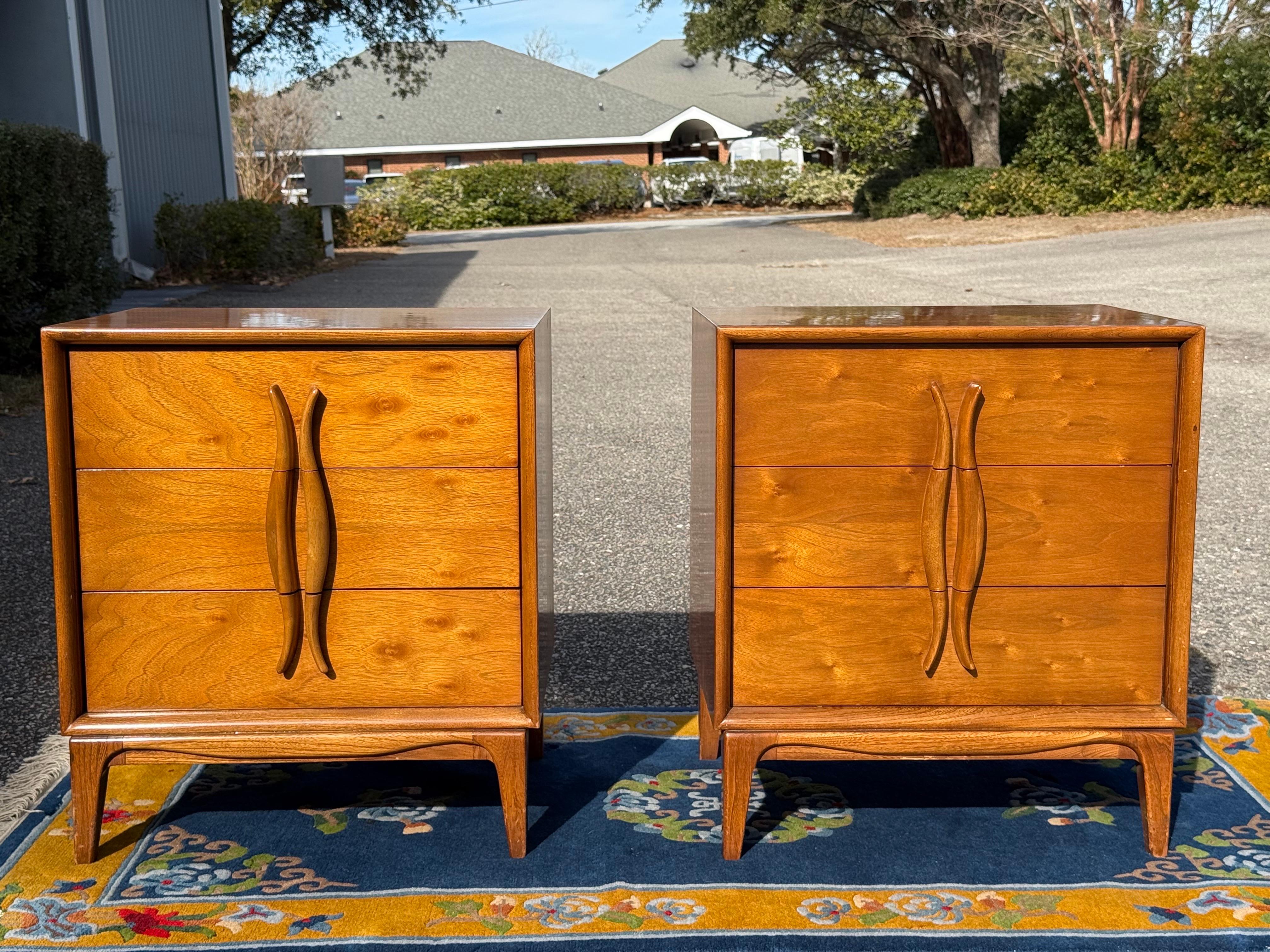 An absolutely stunning pair of 3 drawer nightstands with sexy sculpted pulls.  The drawer fronts are in a satin wood while the case is a light walnut.  These are in their original finish and they still have many many many years left!  The drawers