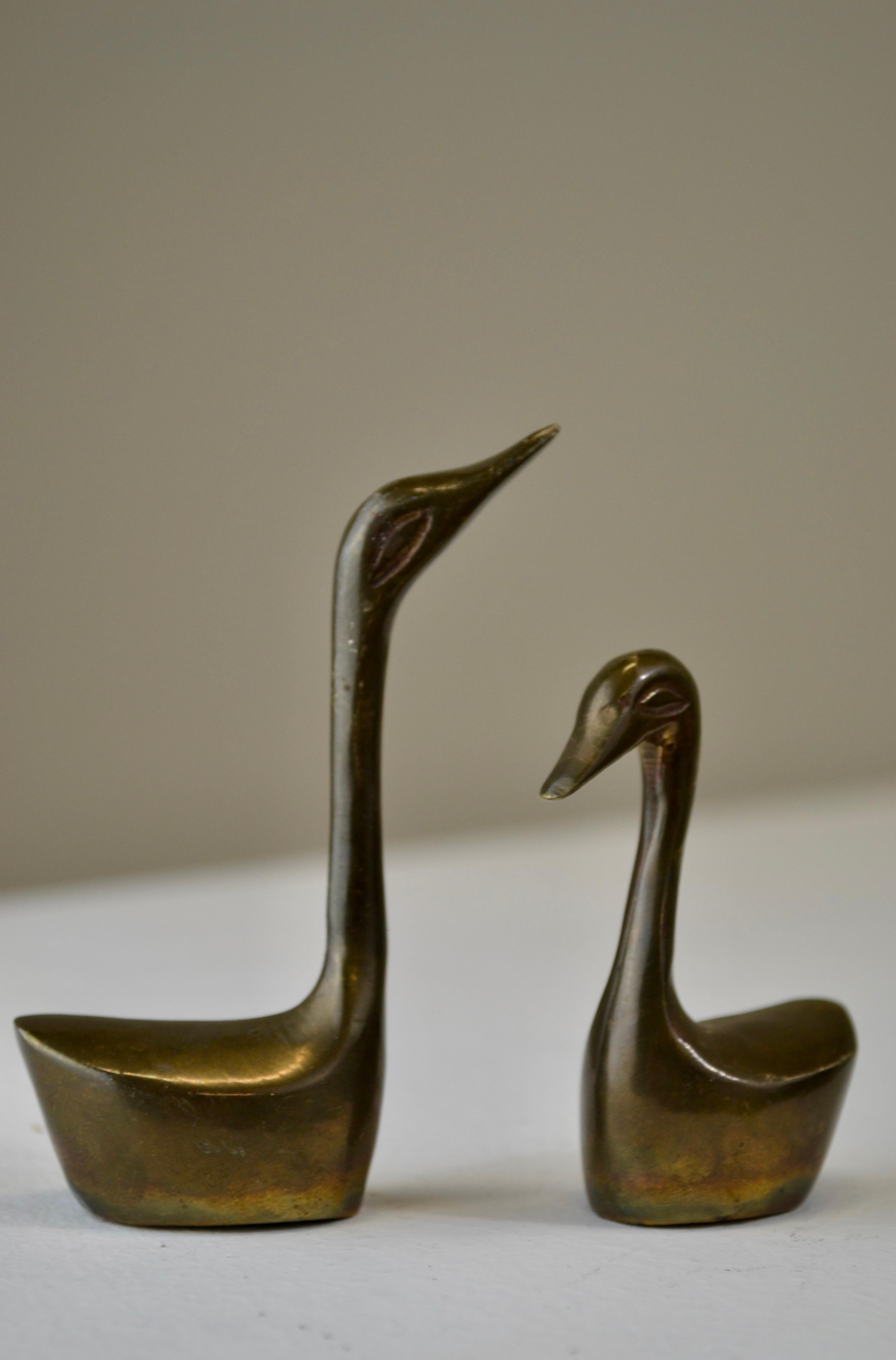 Questo elegante duo, che ricorda il minimalismo scandinavo o giapponese, presenta uccelli acquatici stilizzati con colli allungati e forme semplificate che catturano una presenza aggraziata e contemplativa.

Il bronzo ha sviluppato nel tempo una