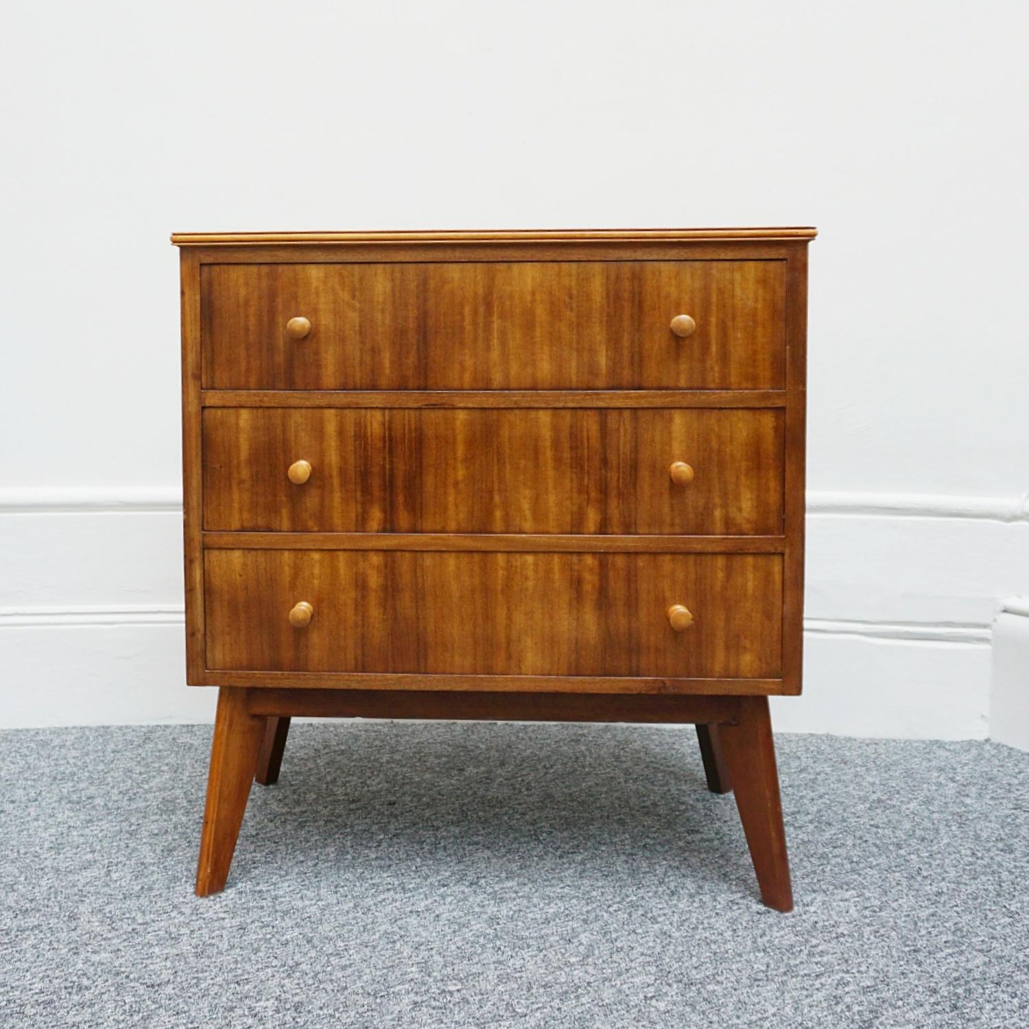 A Pair of Mid-Century 'Cumbrae' range chests of drawers by Moriss of Glasgow. Zebra wood with sycamore banding and handles. Set over outward angled legs. Four well proportioned drawers. labelled to inside of upper drawer and to back of each chest.