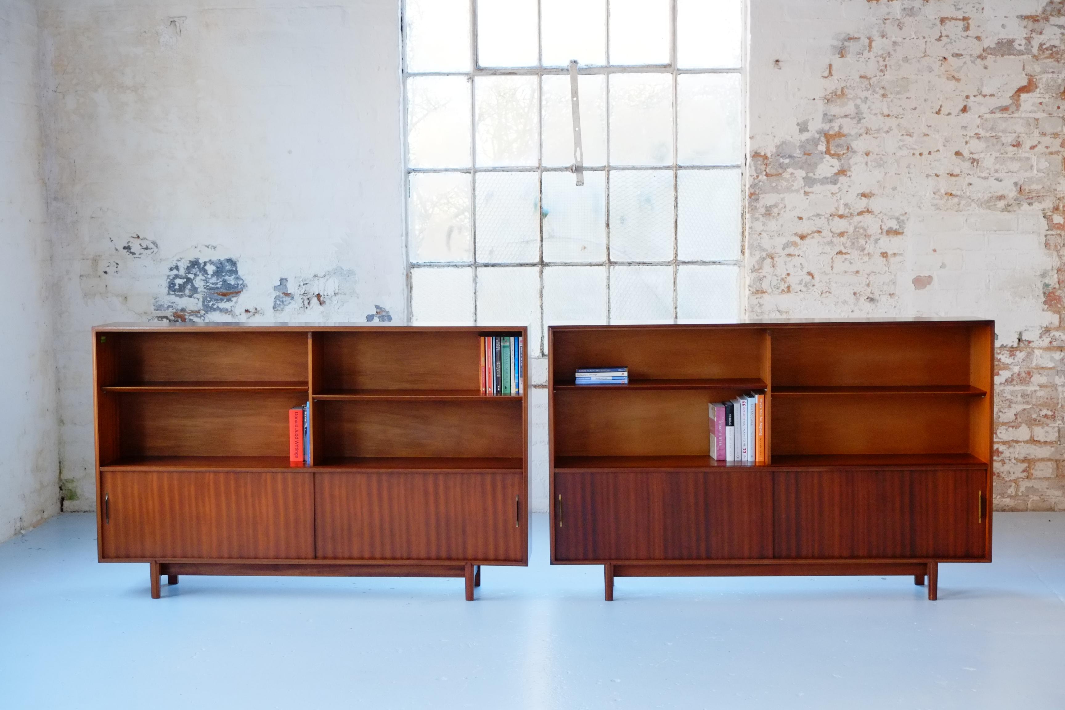 This is a pair of beautiful long slim glazed bookcases from the 1960s. These Mid-century modern cabinets were designed by Robert Heritage as part of the Multi-Width series for Beaver and Tapley. Beaver and Tapley was a mid-century British furniture