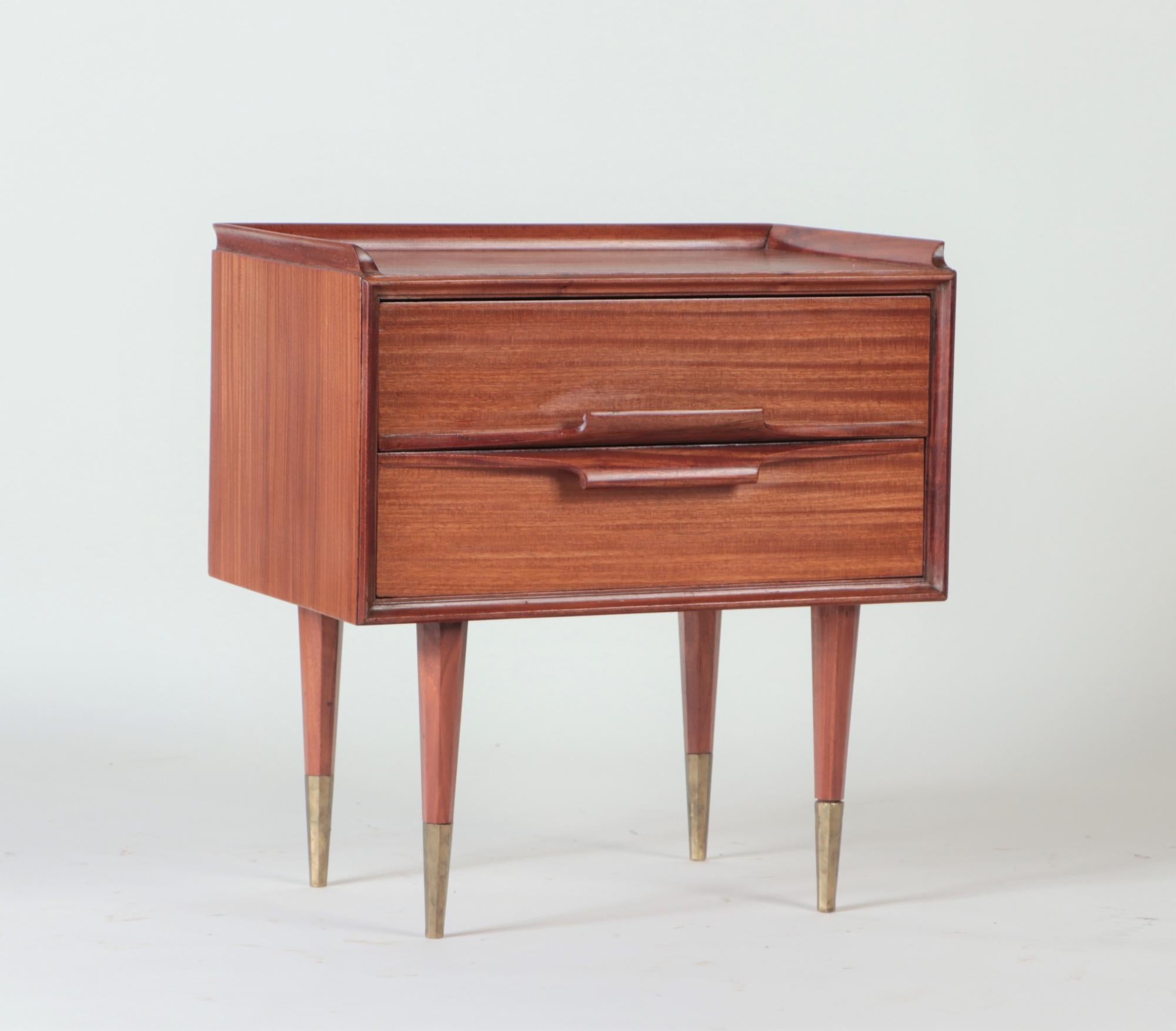 A pair of Mid-Century Modern Italian mahogany two drawers night stands resting on four tapered legs ending in brass sabots circa 1950.