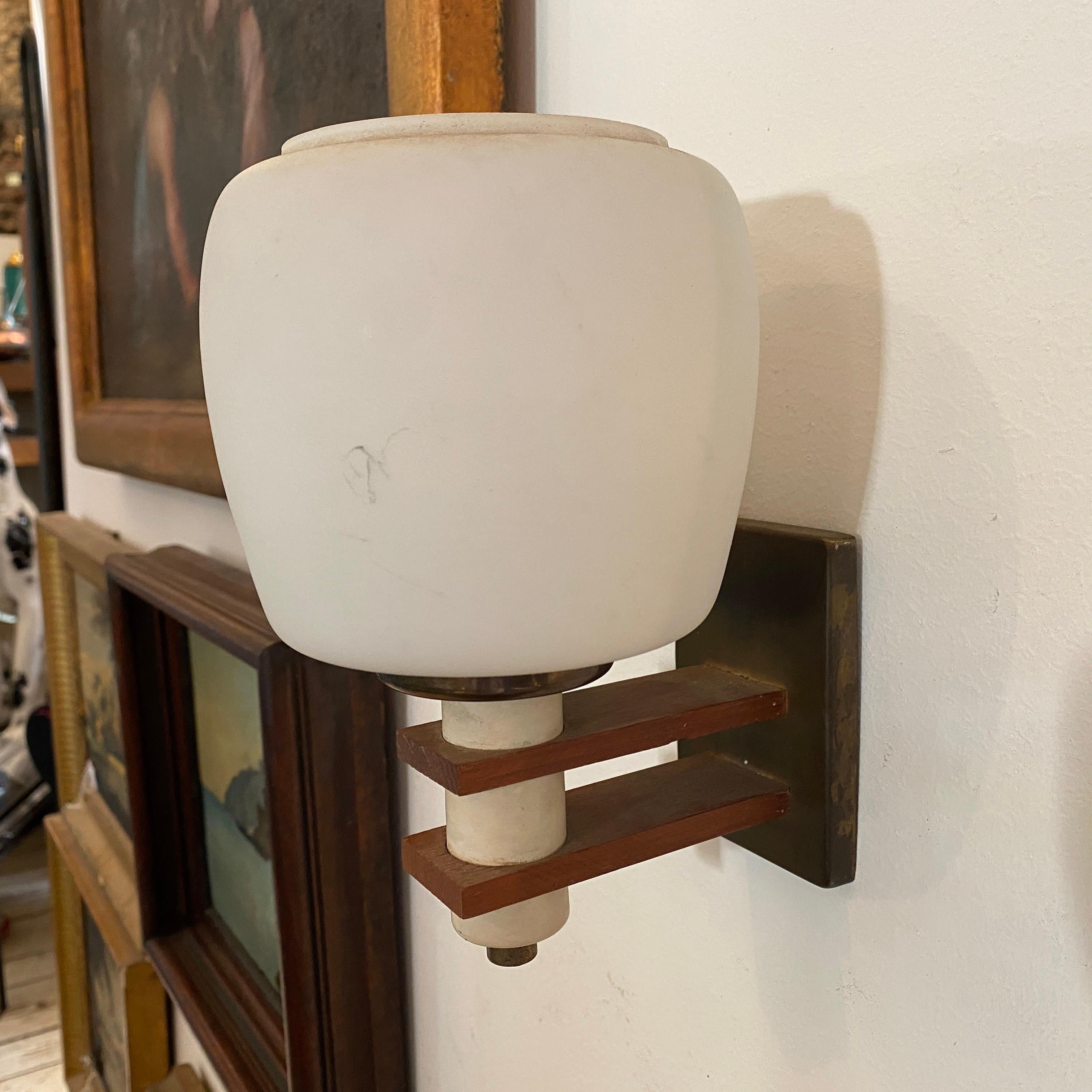 Two brass, white glass and teak Italian wall sconces, all in original conditions, they work 110-240 volts and need regular e14 bulbs.