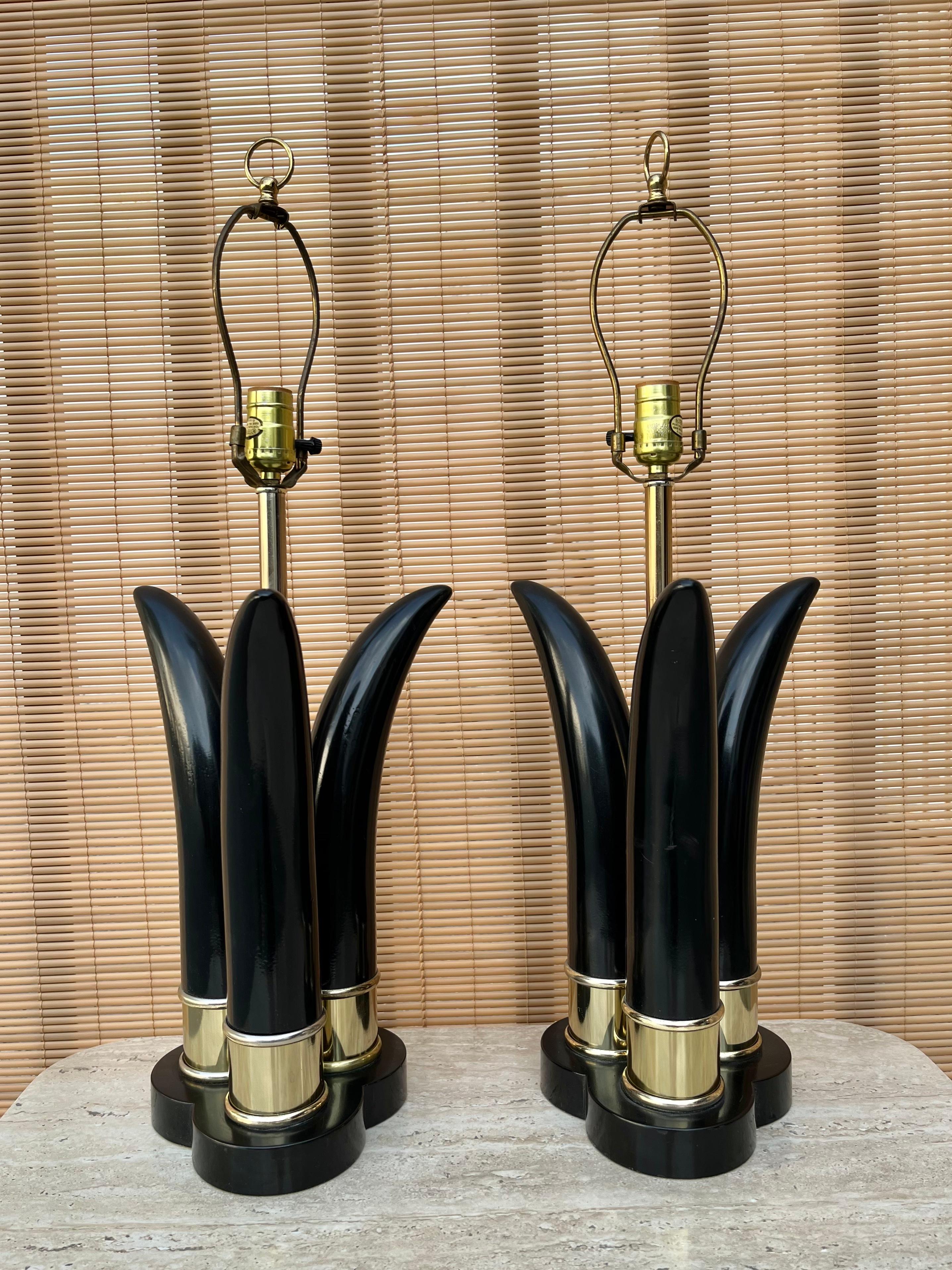 A pair of Vintage Mid-Century Modern sculptural black and brass table lamps. Circa early 1970s. 
Feature three black lacquered horn shaped sculptural elements with brass pleated rings at the base, a brass stand to hold the lightbulb and brass ring