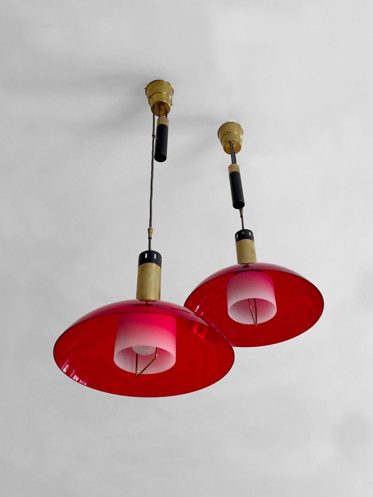 An exceptional pair of counterweight pendants, Modernist, Bauhaus, Constructivist, Free Form, in black lacquered metal, gilded brass, white opaline glass and red perspex, Stilux edition, Italy 1950-1960.

DIMENSIONS OF EACH PENDANT: Diam 40 x H 30